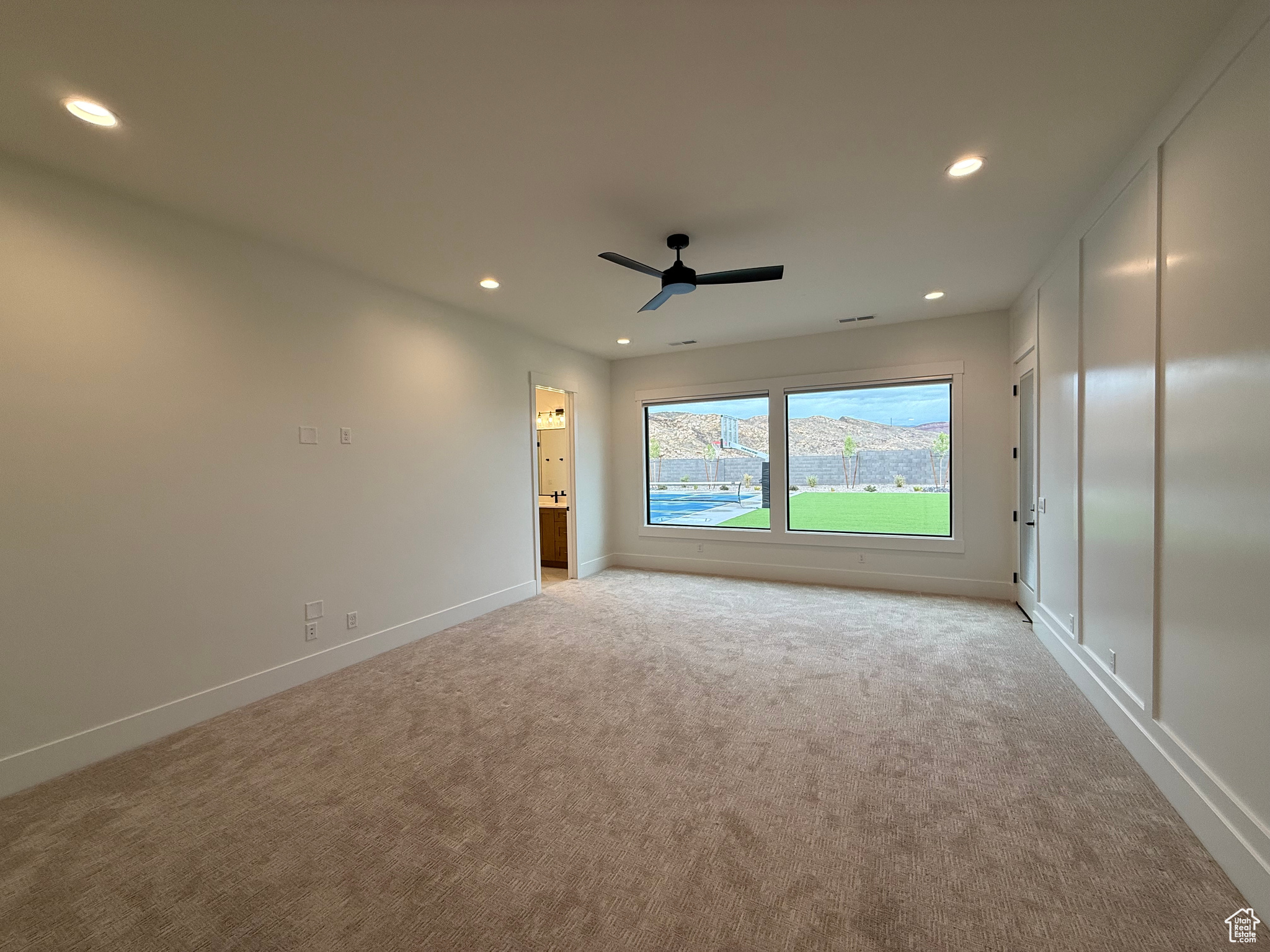 Empty room featuring recessed lighting, light colored carpet, and baseboards