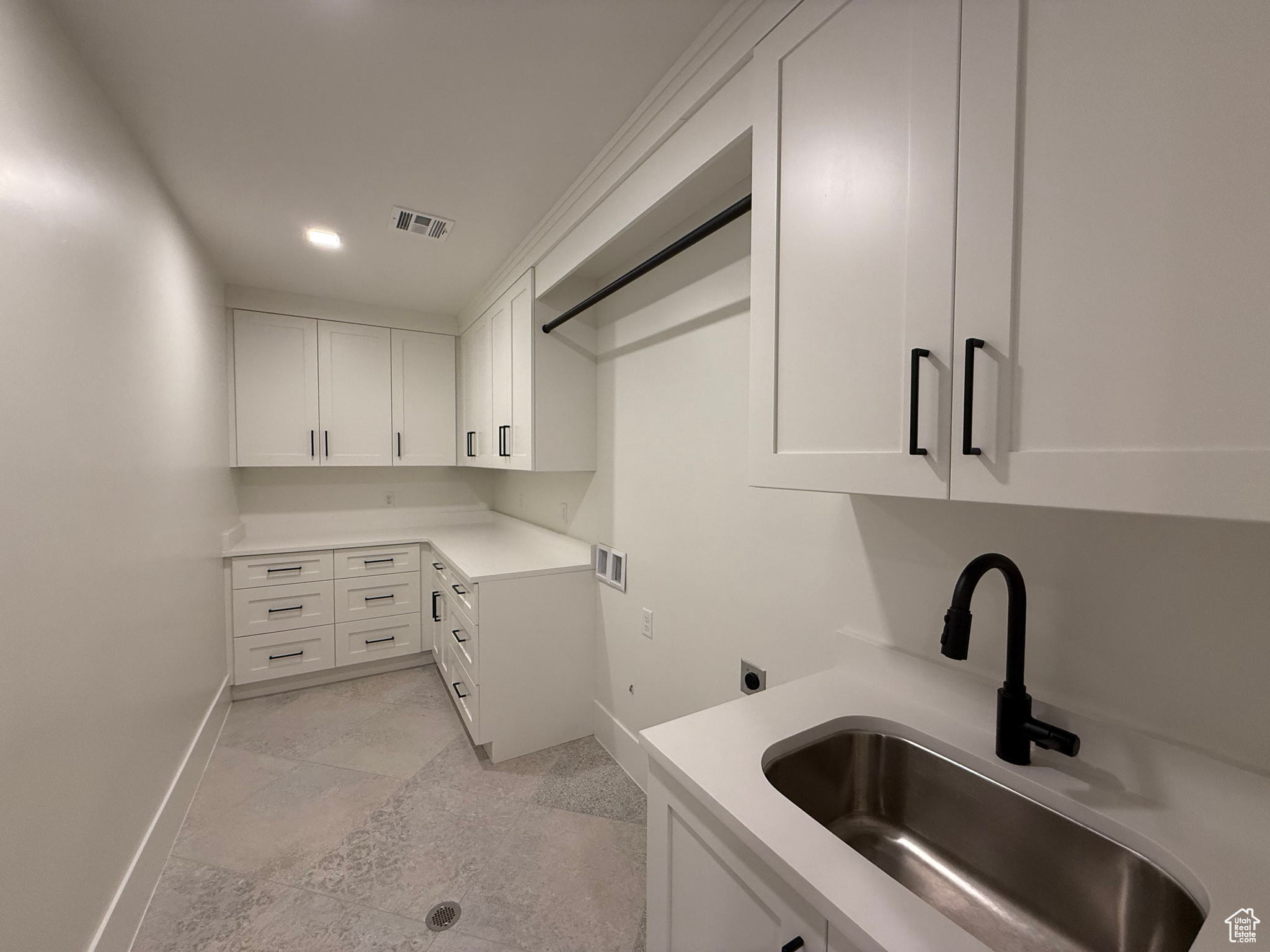 Washroom with visible vents, cabinet space, electric dryer hookup, washer hookup, and a sink