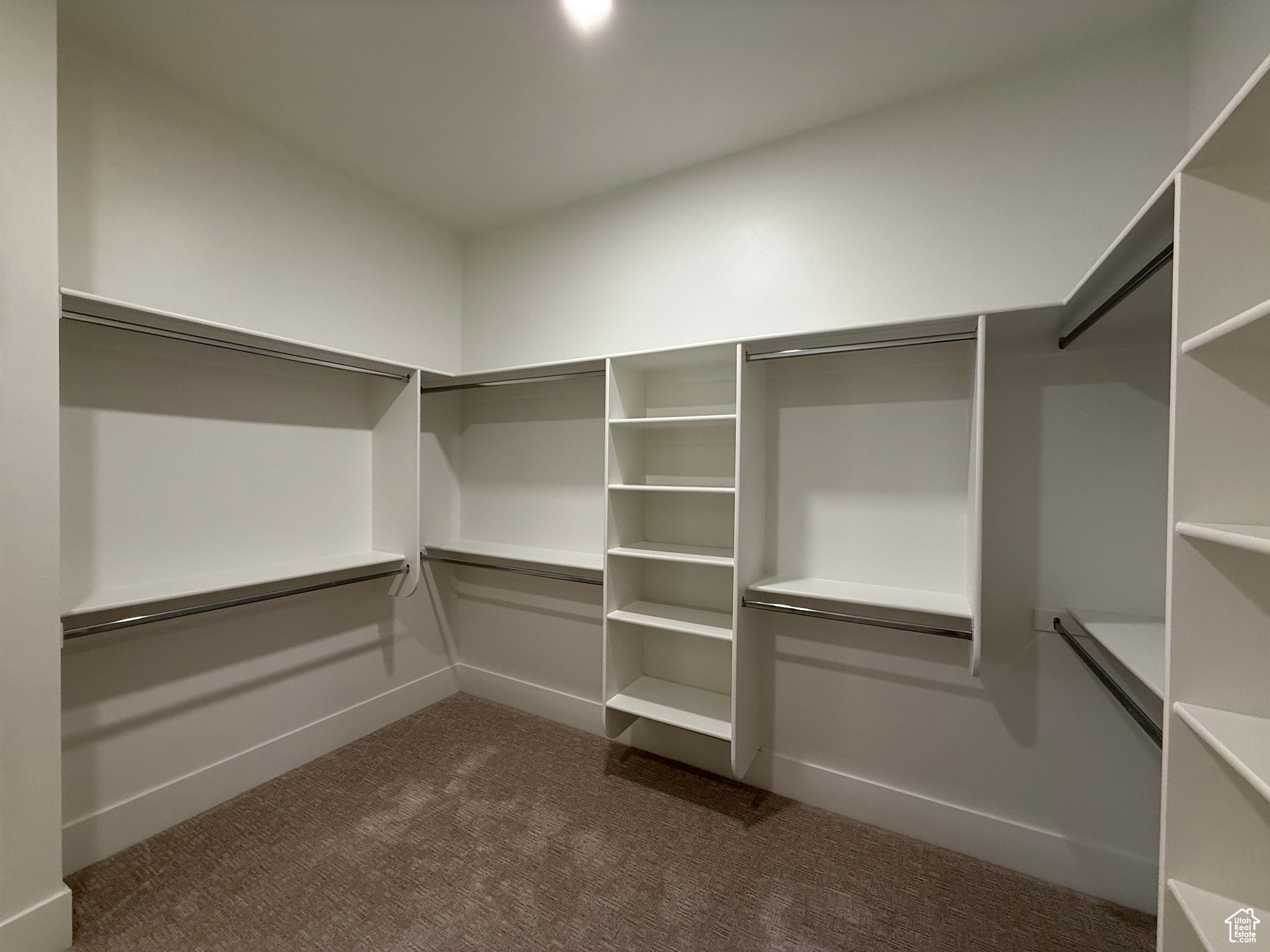 Spacious closet with dark carpet