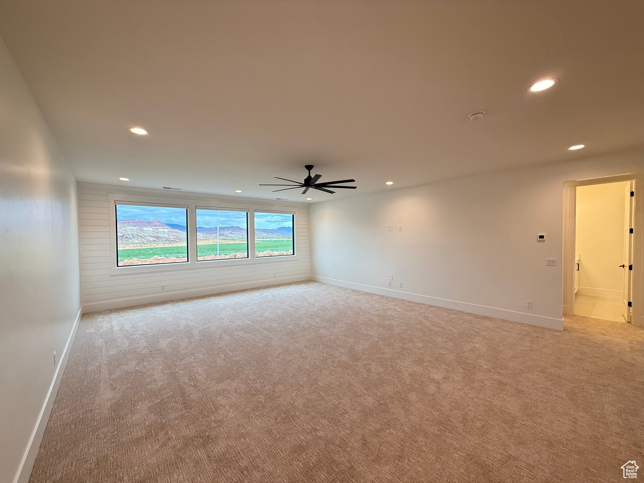 Spare room featuring ceiling fan, recessed lighting, baseboards, and light carpet