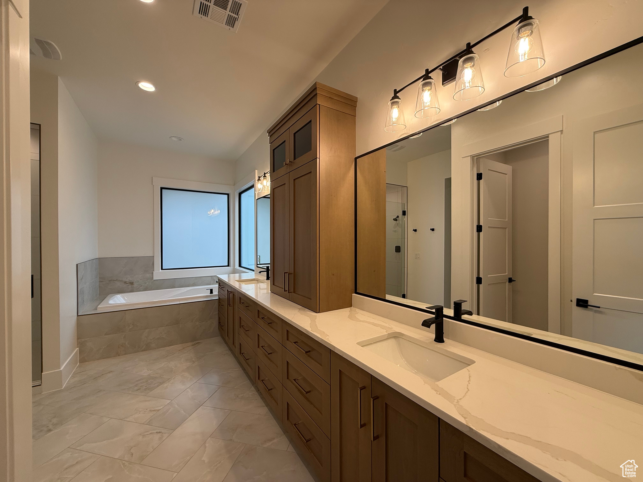 Full bath with visible vents, marble finish floor, a sink, double vanity, and a bath