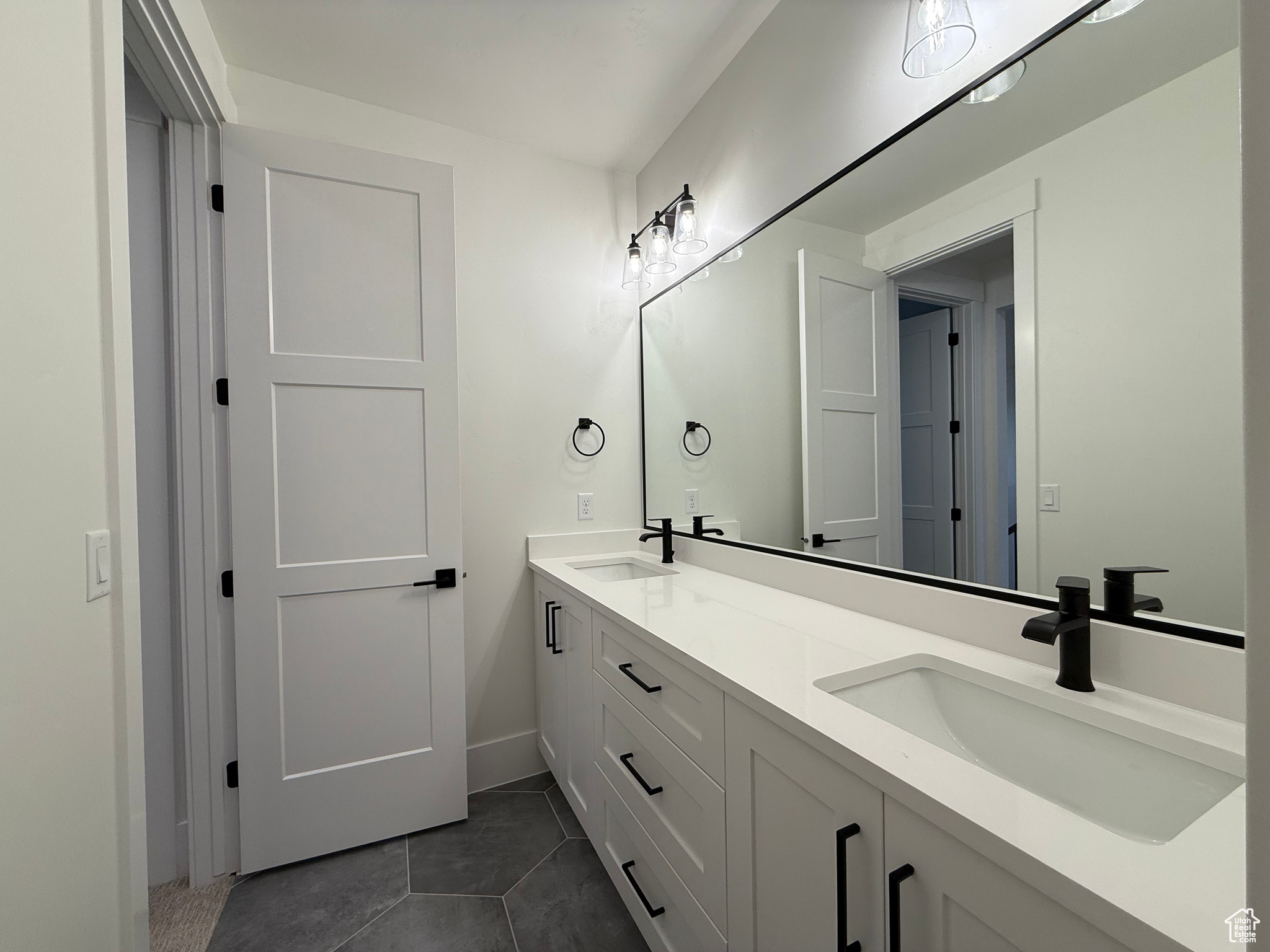 Full bath featuring a sink, double vanity, and tile patterned floors