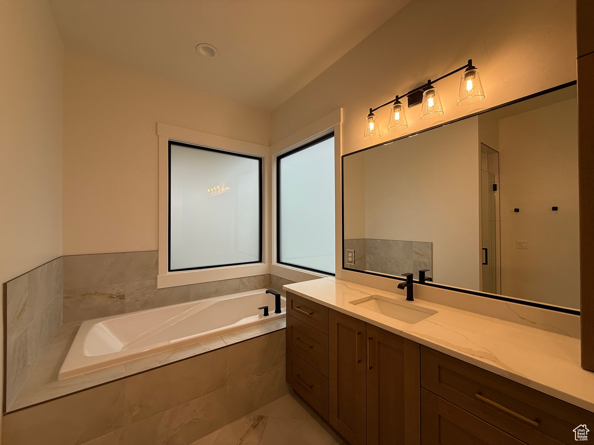 Full bath with vanity, a shower stall, a bath, and marble finish floor