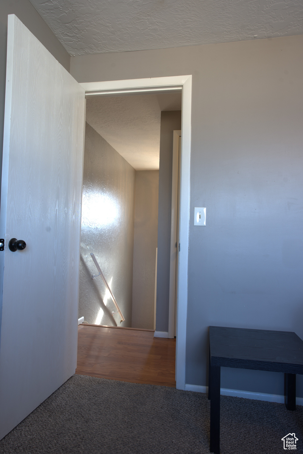 Hallway with carpet and a textured ceiling