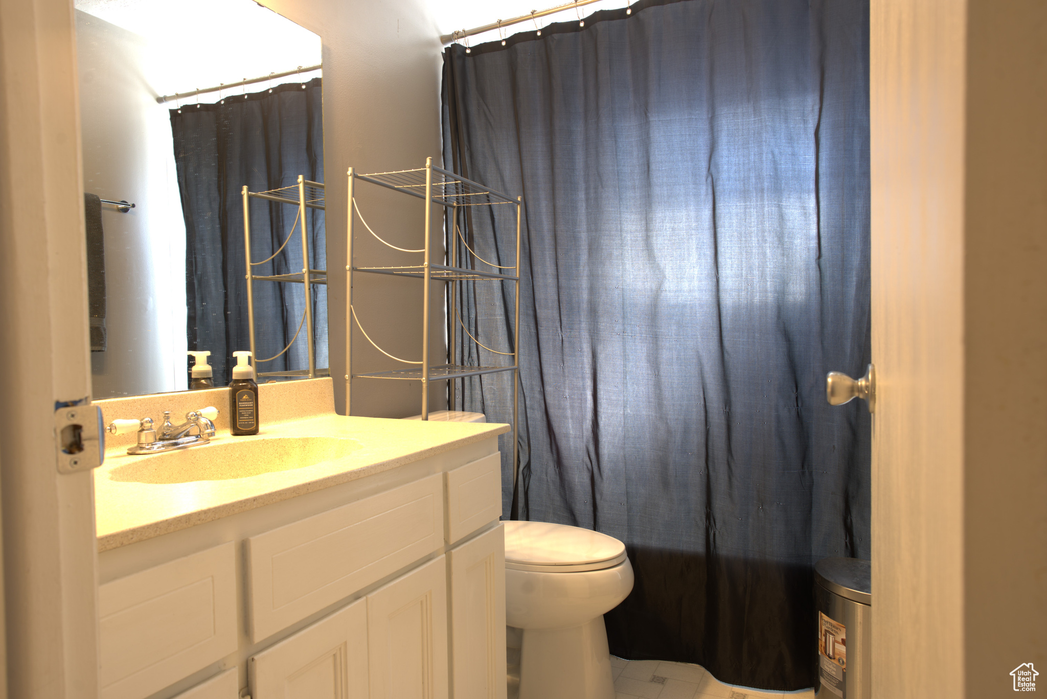 Full bath featuring vanity, toilet, and a shower with curtain