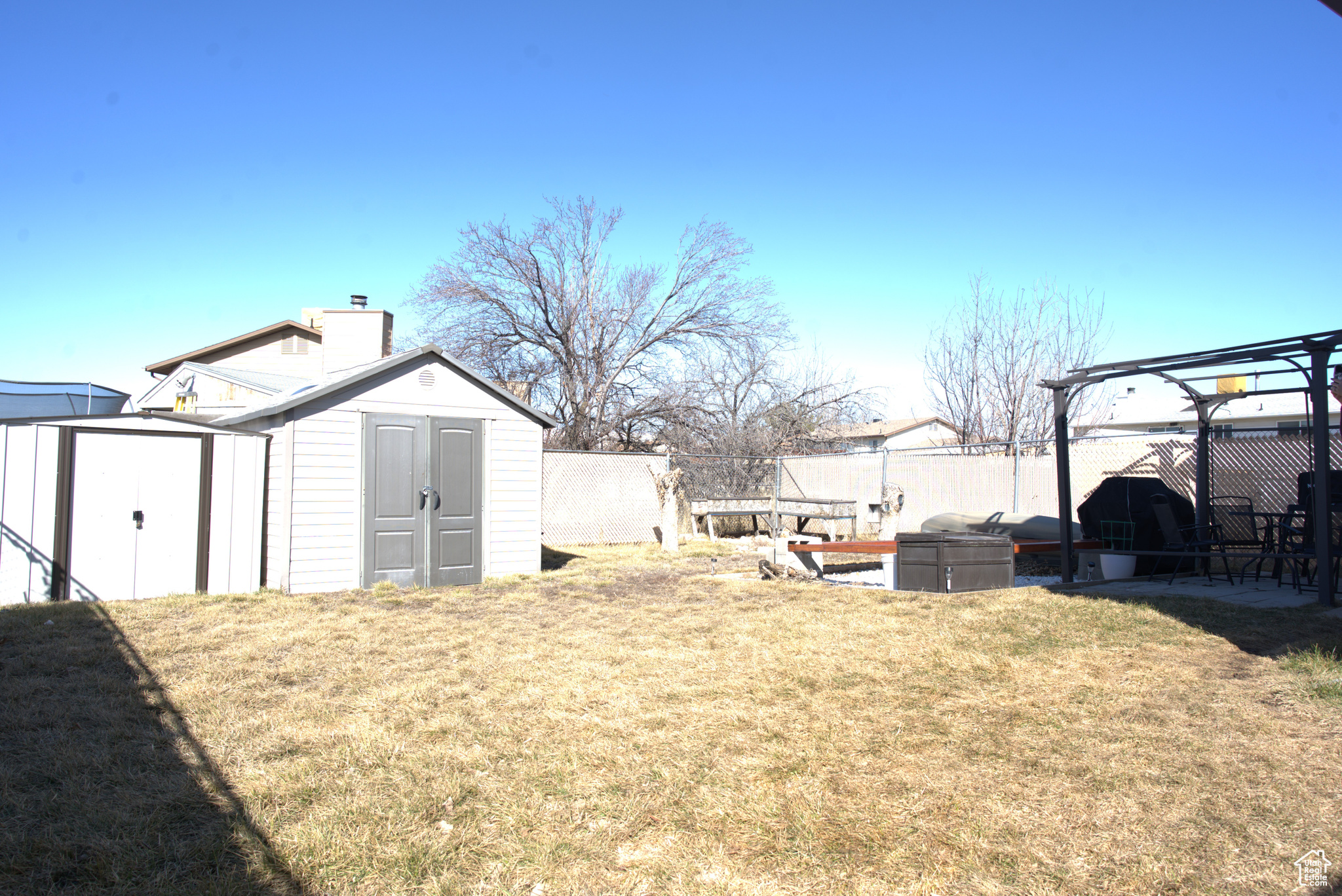 View of yard featuring a storage unit, an outdoor structure, and fence