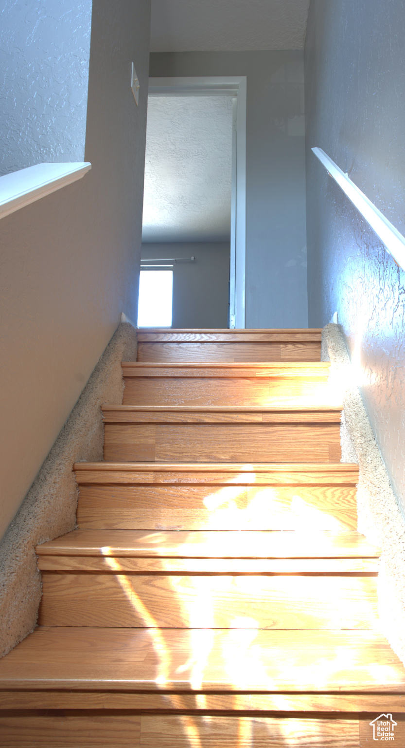 Stairway featuring a textured ceiling