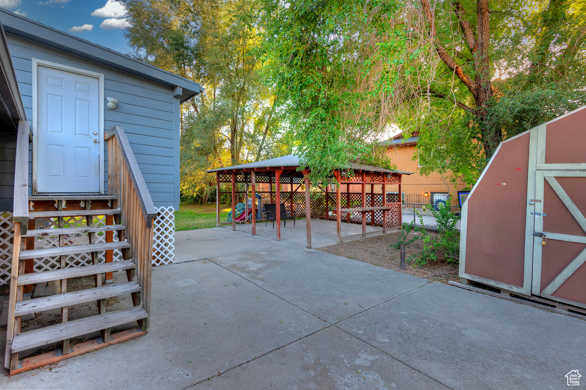 View of patio featuring fence, an outdoor structure, and a shed