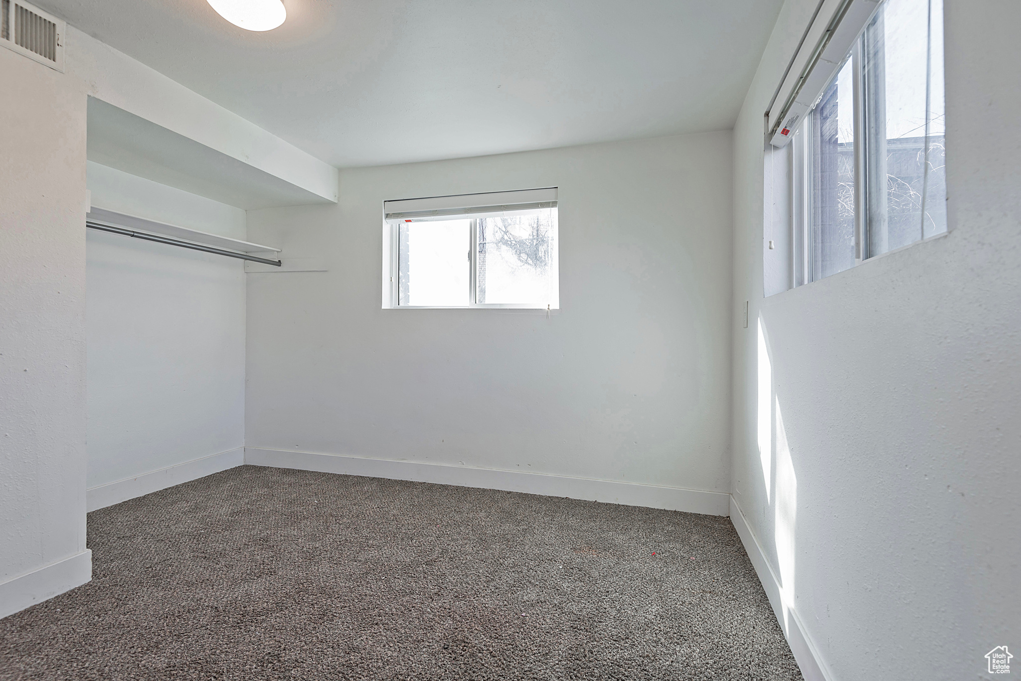 Unfurnished bedroom featuring visible vents, carpet floors, and baseboards