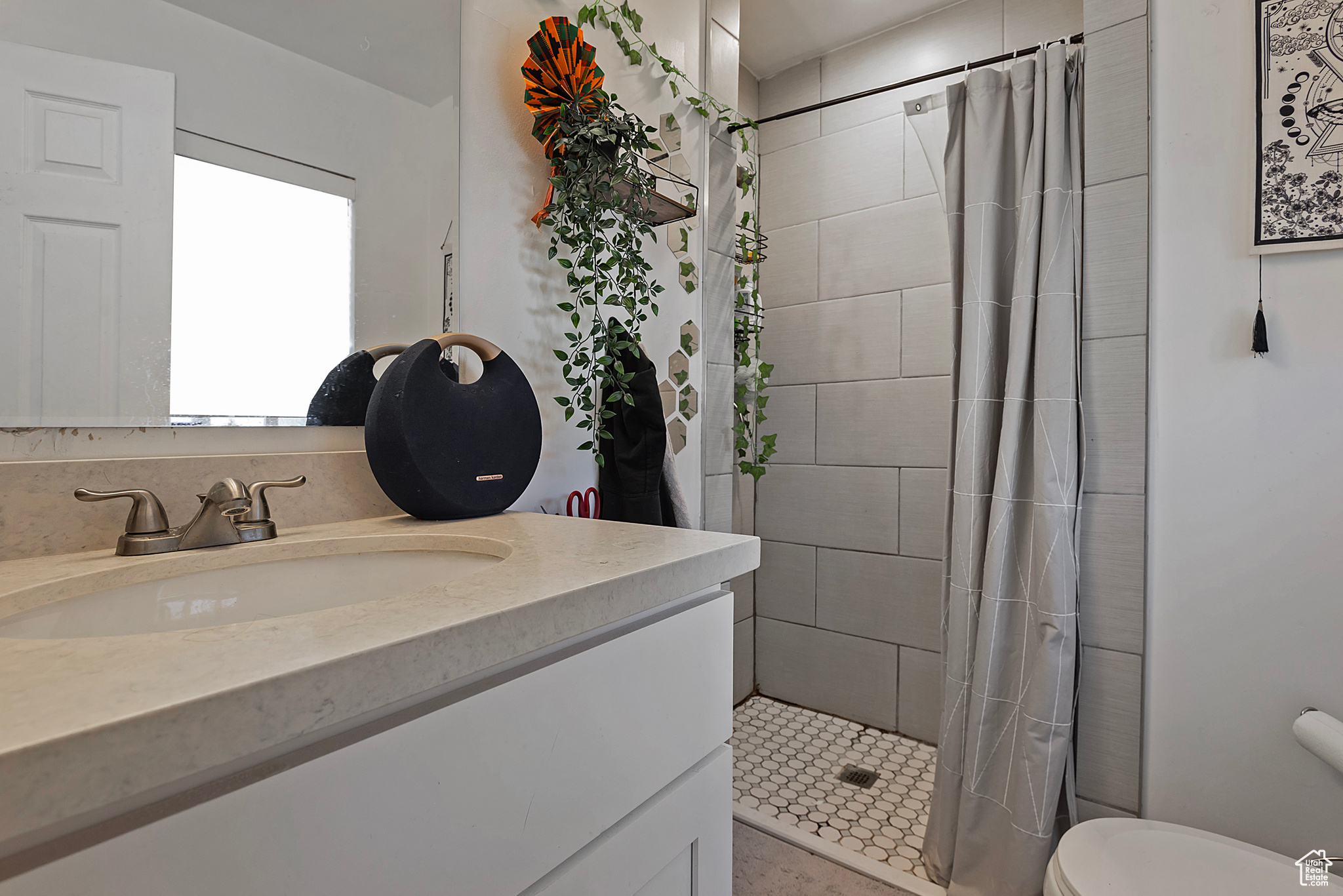 Full bathroom with tiled shower, toilet, and vanity