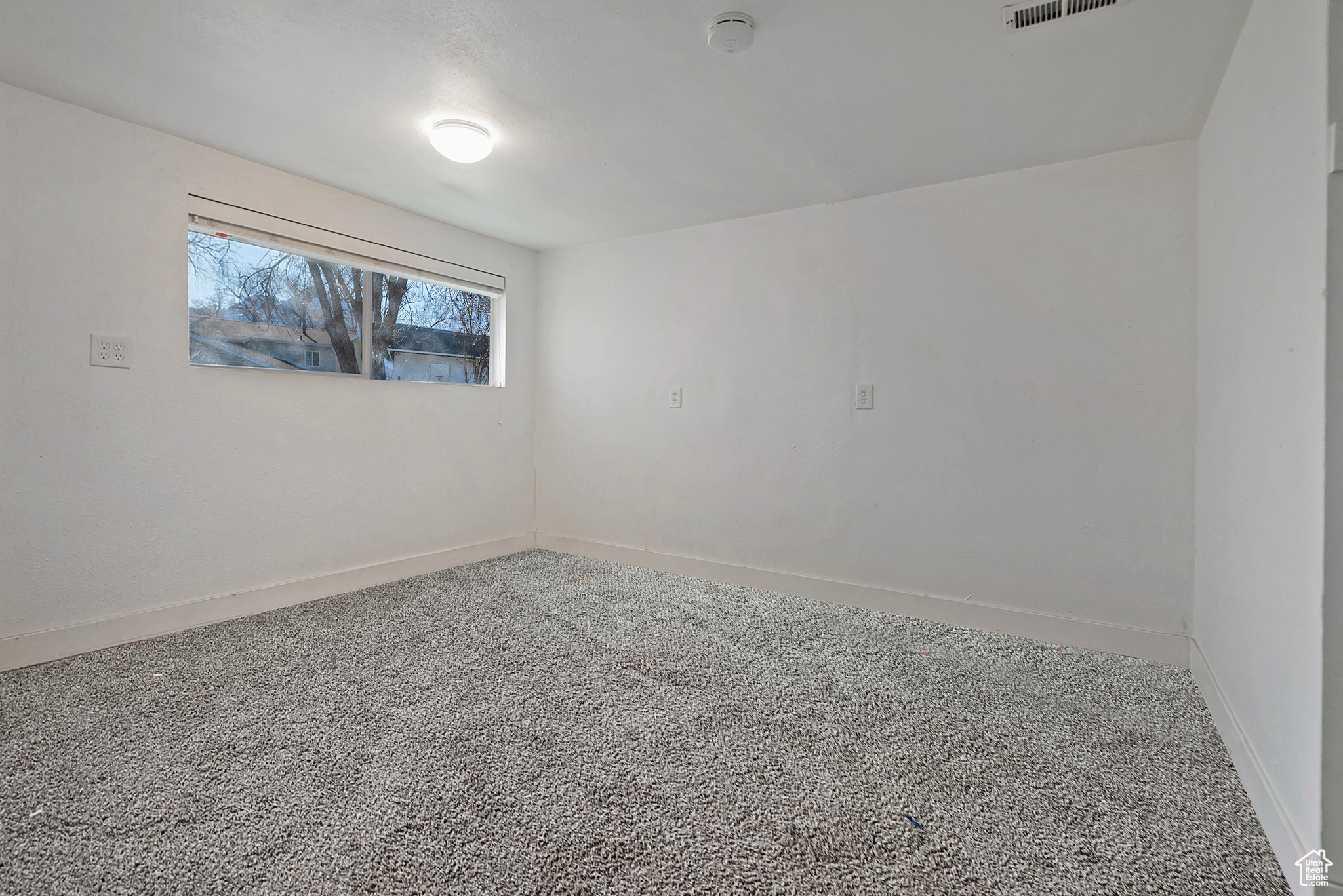 Spare room with baseboards and carpet