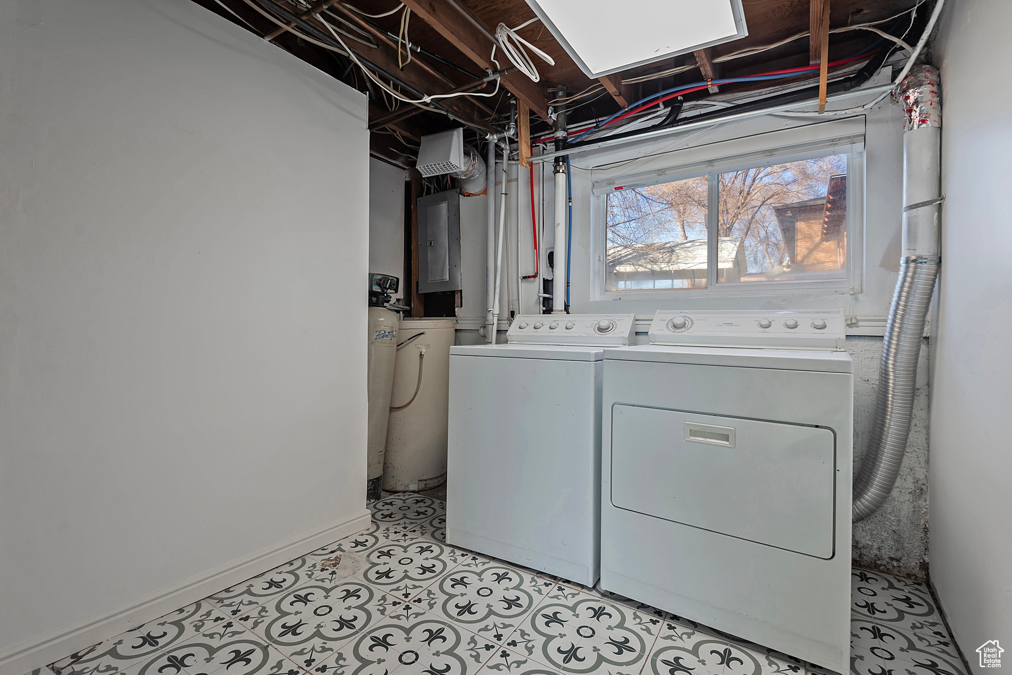 Clothes washing area featuring washing machine and clothes dryer, laundry area, and electric panel