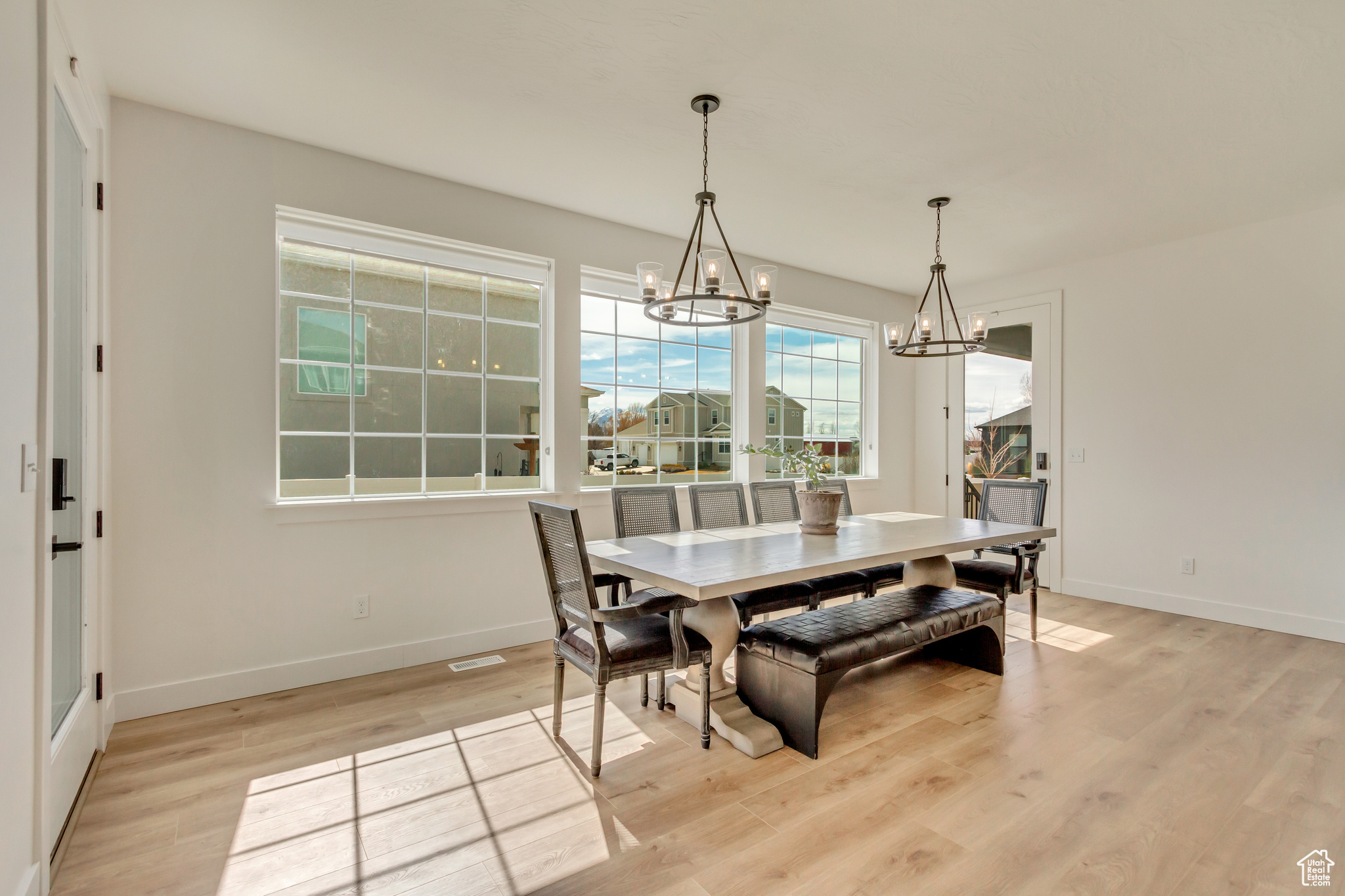 Dining room with baseboards, light wood-style floors, and a chandelier