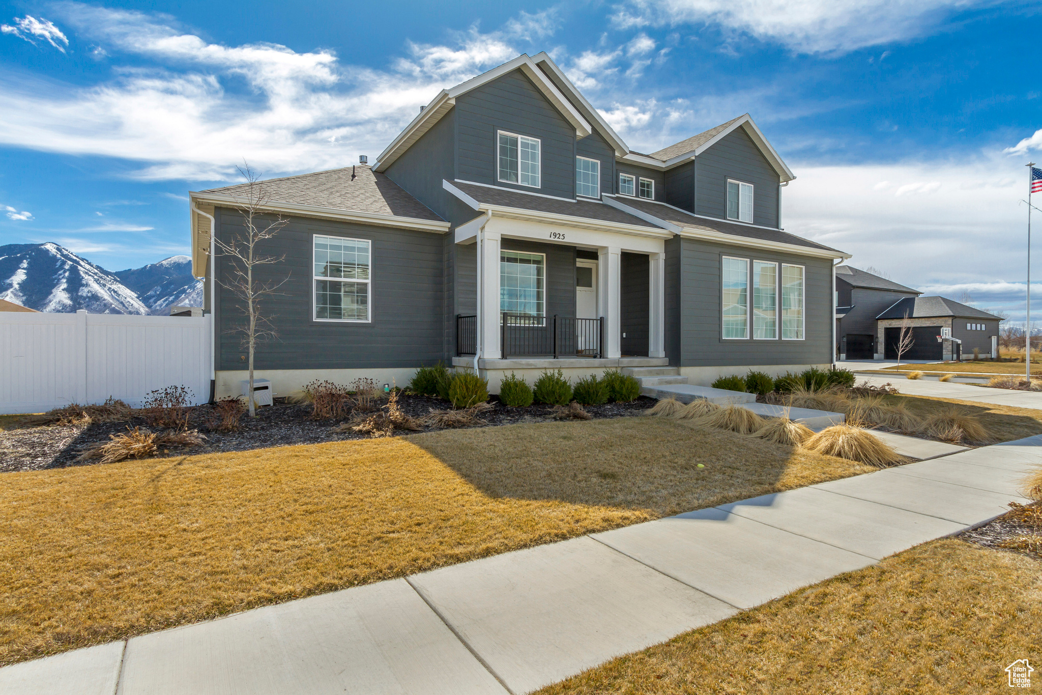 View of front of property with a mountain view, a porch, a front yard, and fence