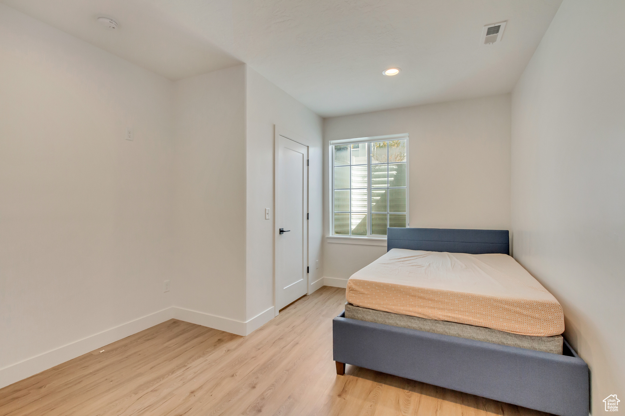 Bedroom with recessed lighting, light wood-style floors, and baseboards