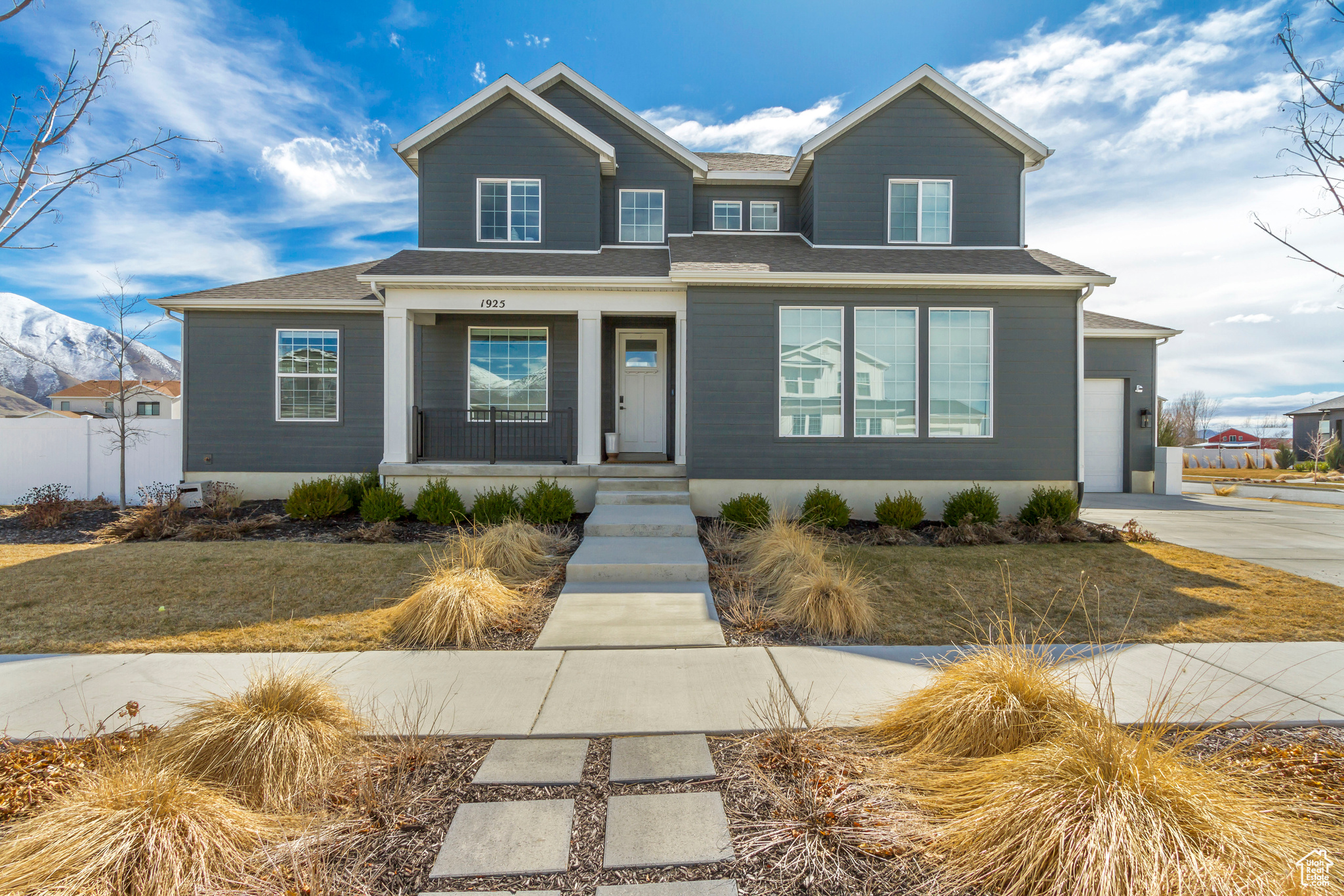 View of front facade featuring a garage, covered porch, and driveway