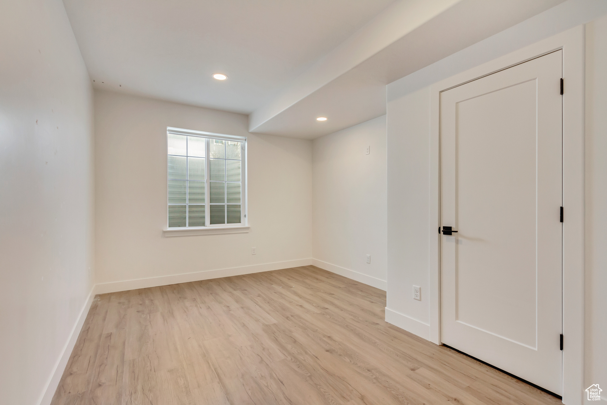 Spare room with recessed lighting, light wood-type flooring, and baseboards