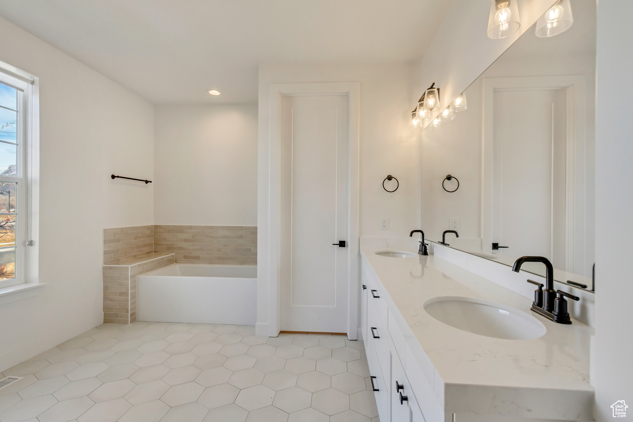 Full bathroom featuring a sink, recessed lighting, a bath, and double vanity