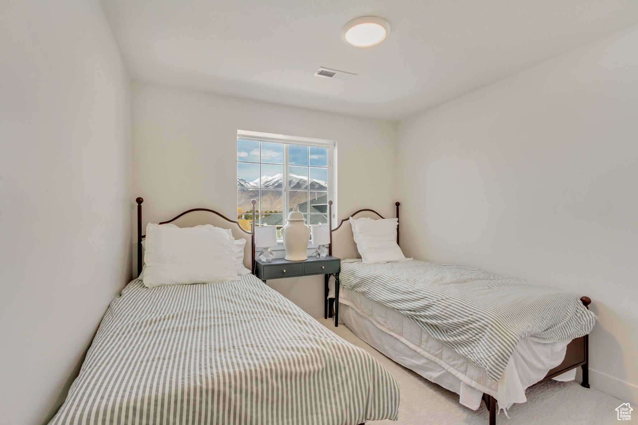 Carpeted bedroom with visible vents and baseboards