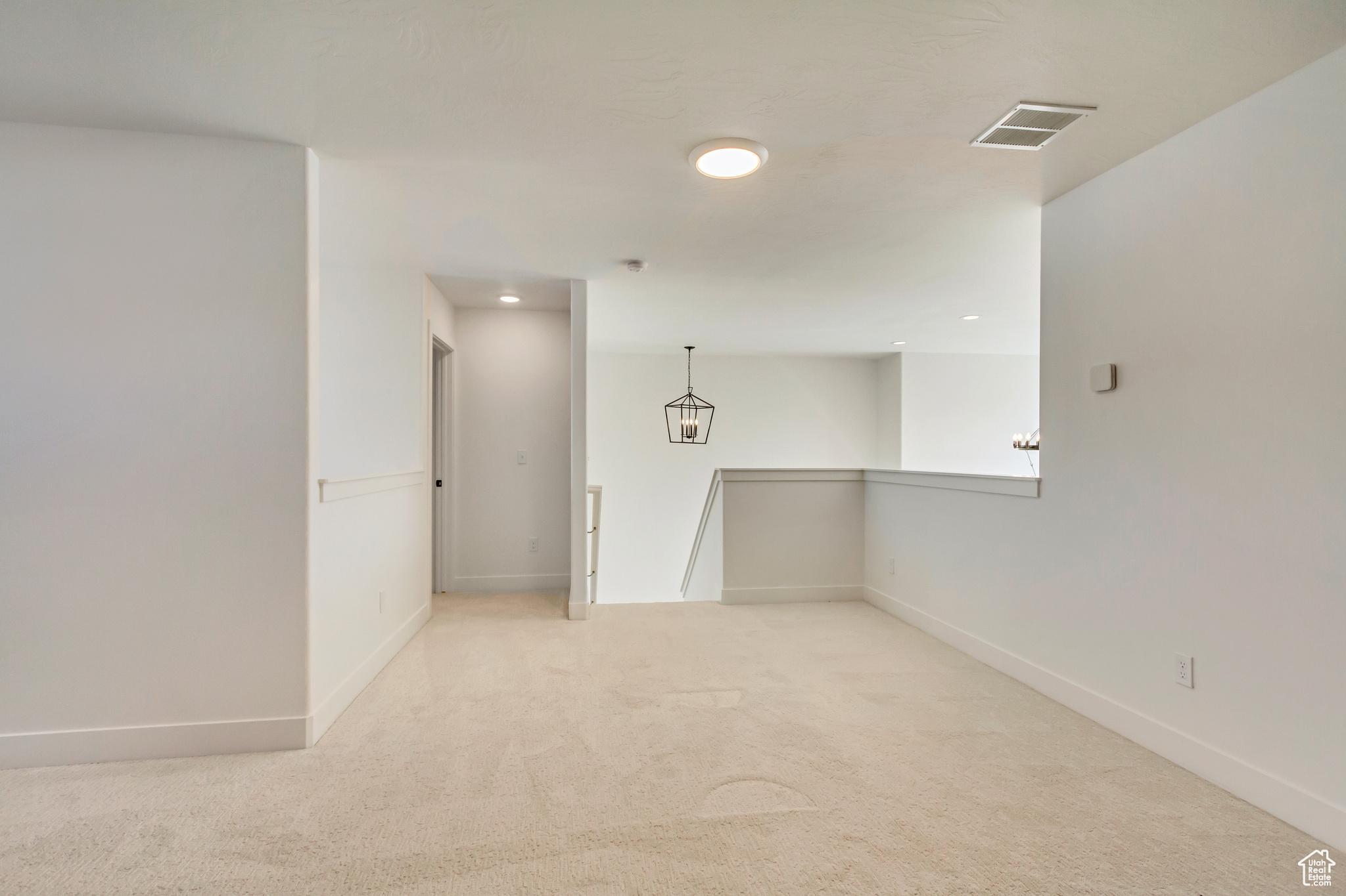 Unfurnished room featuring visible vents, baseboards, and light colored carpet