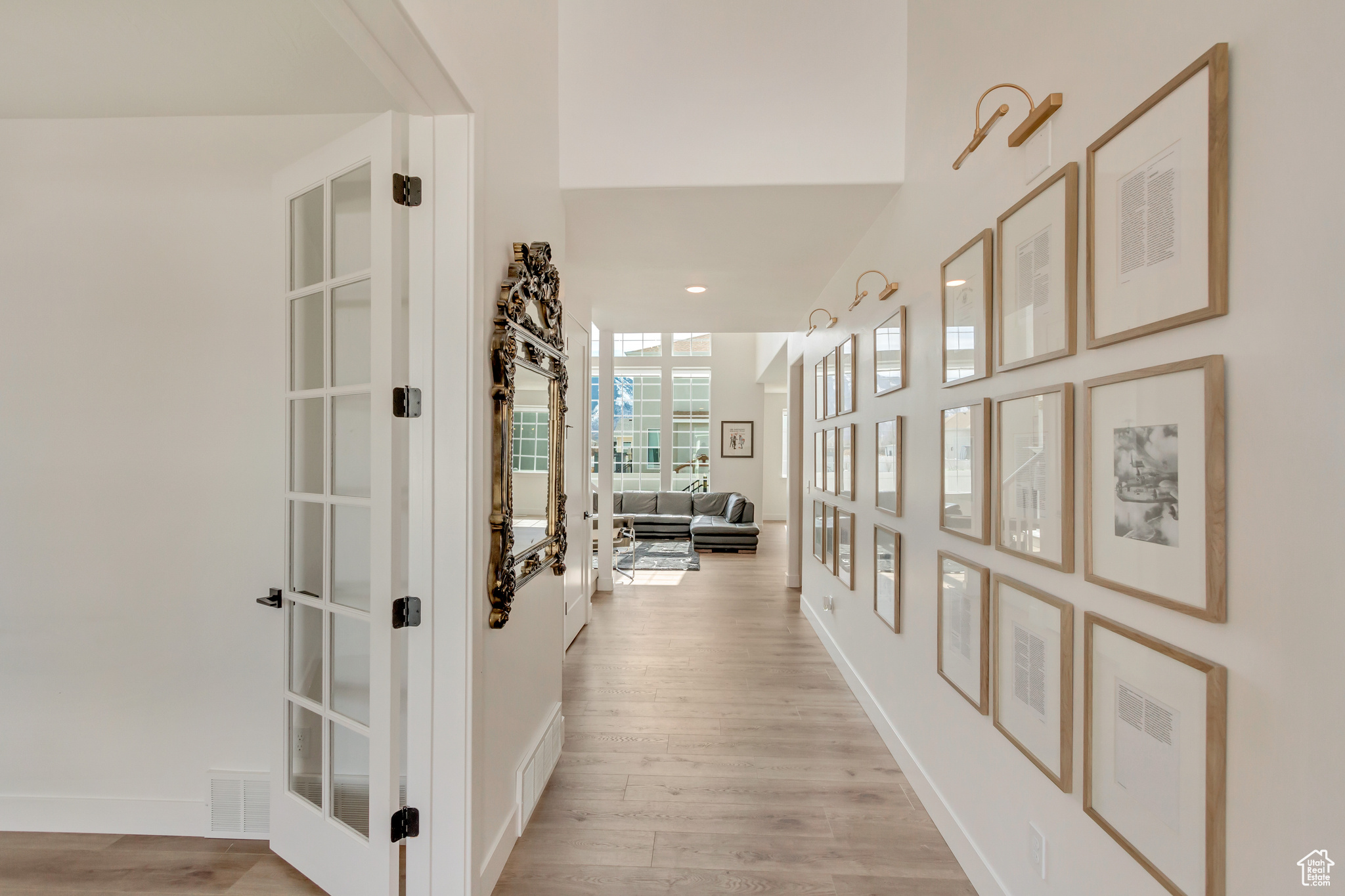 Hallway with french doors, visible vents, light wood finished floors, and baseboards