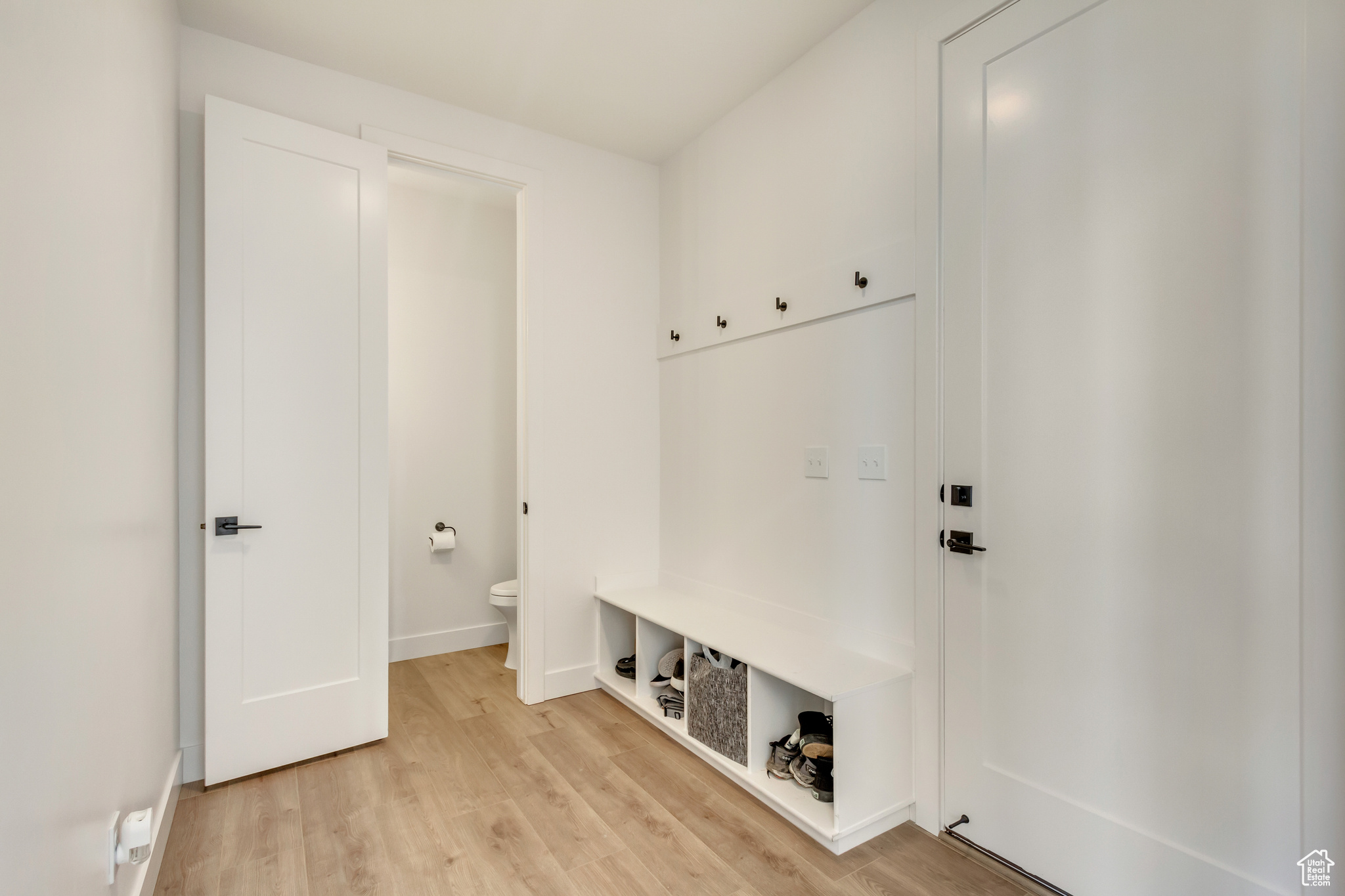 Mudroom featuring light wood-style flooring and baseboards