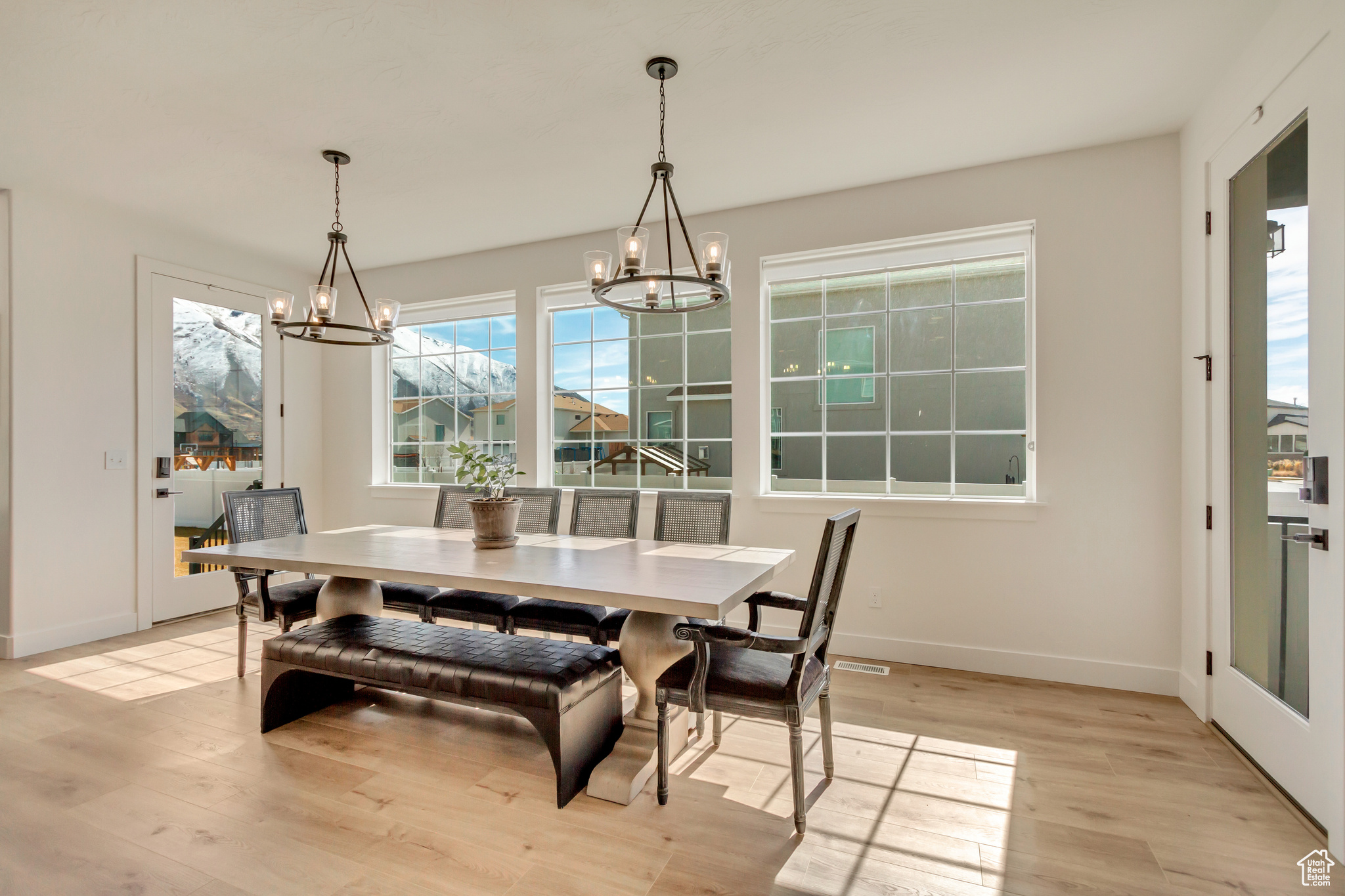 Dining space with light wood-type flooring, baseboards, and an inviting chandelier