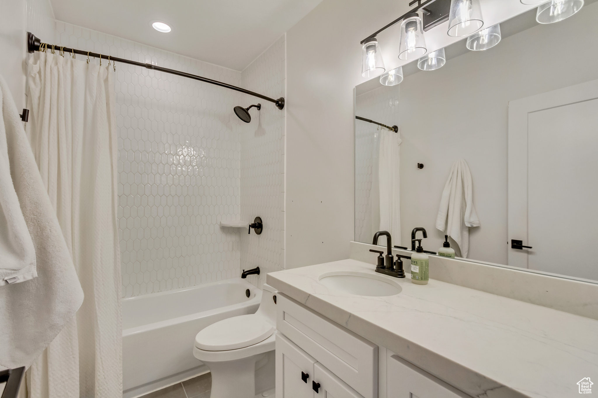 Full bath with shower / bathtub combination with curtain, toilet, vanity, and tile patterned flooring