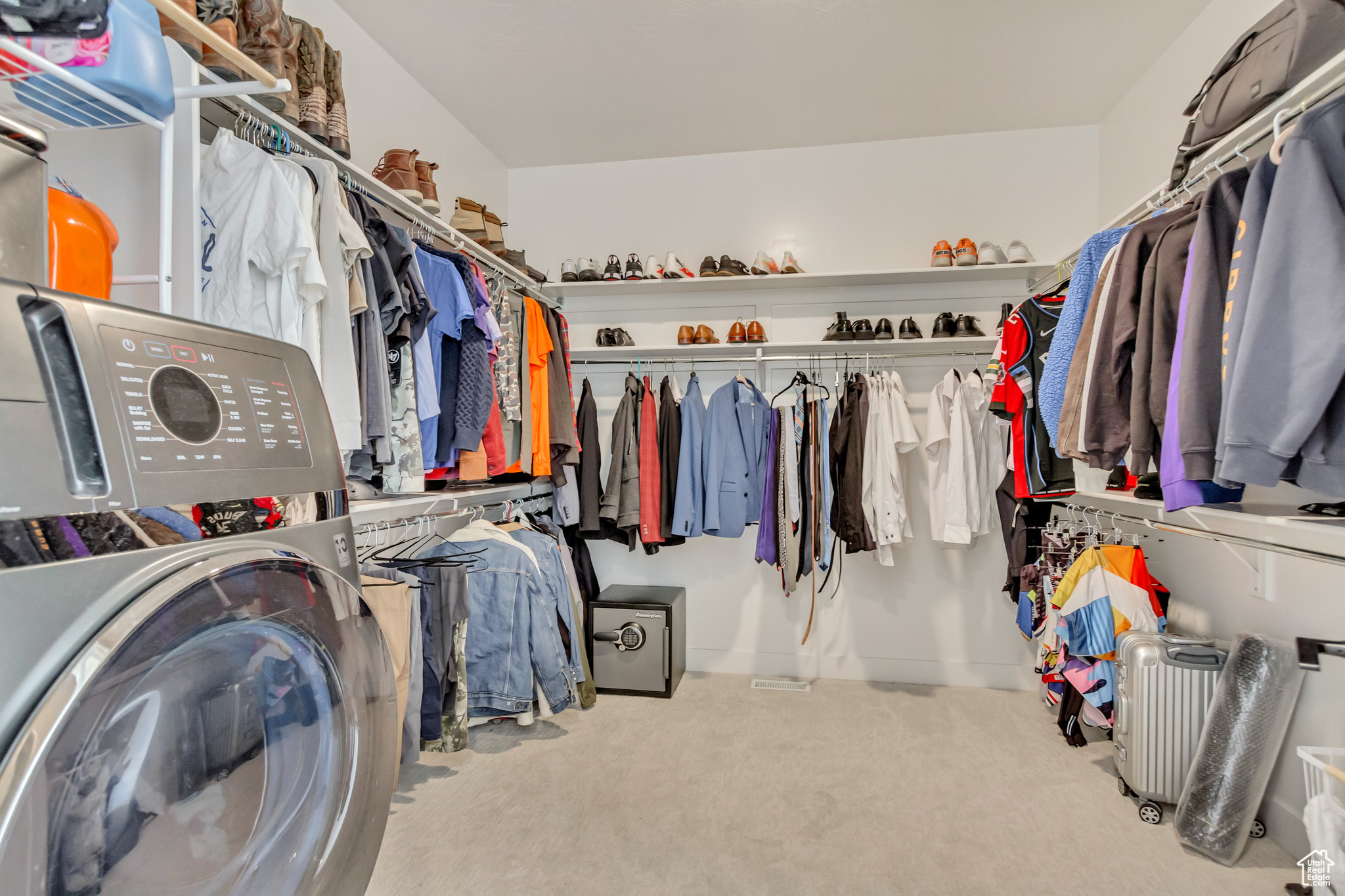 Walk in closet with washer / dryer and carpet floors