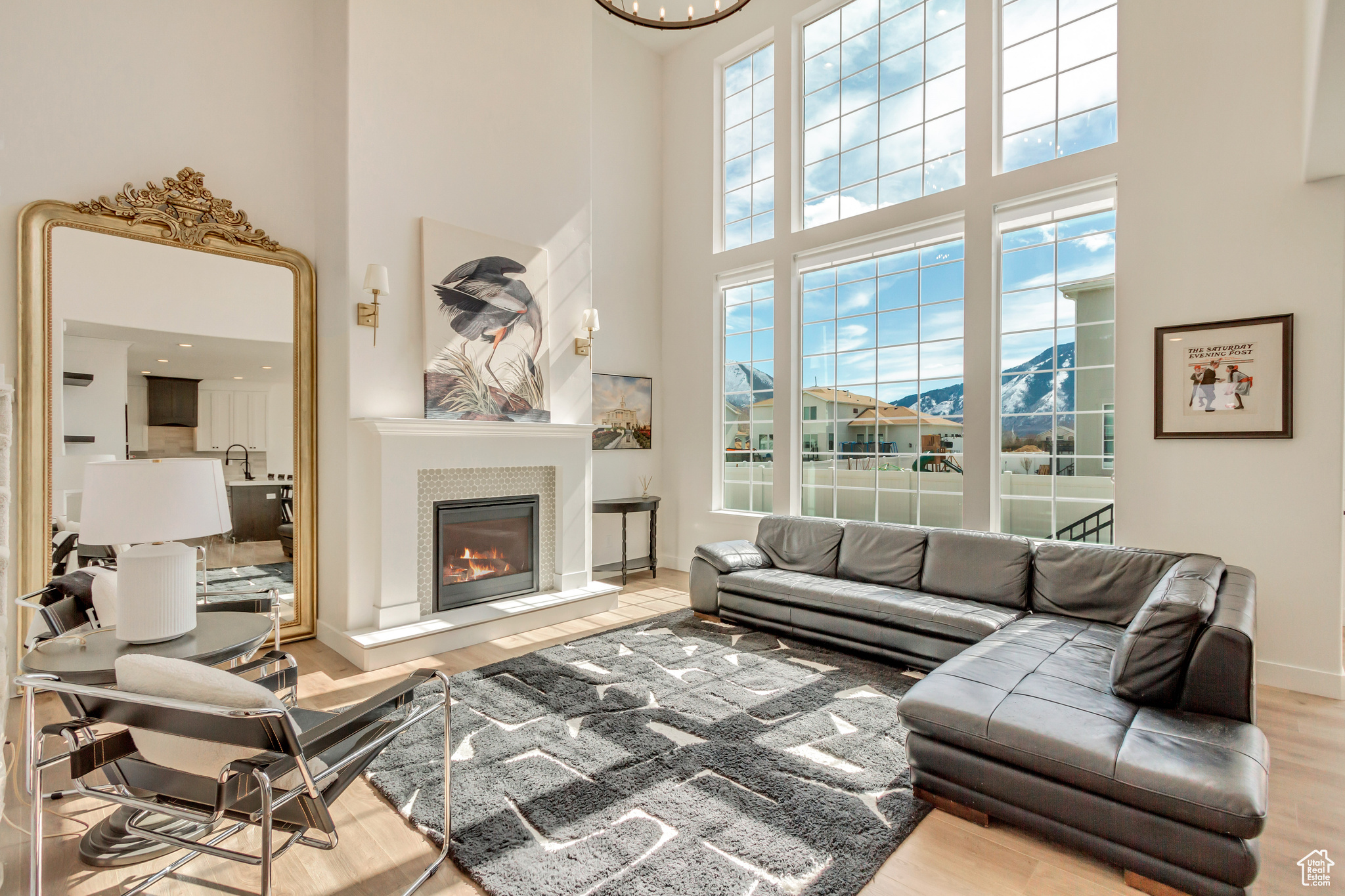 Living area featuring a glass covered fireplace, baseboards, a healthy amount of sunlight, and wood finished floors