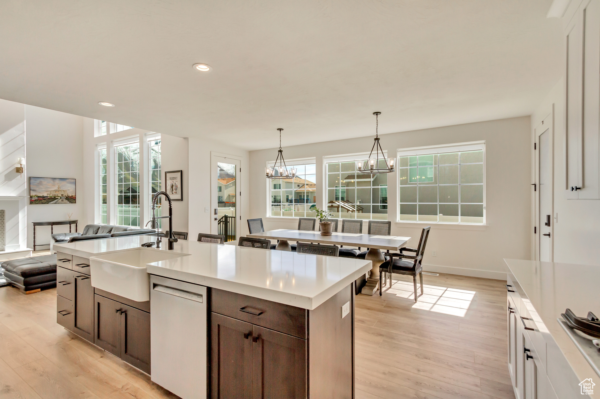 Kitchen featuring light wood finished floors, dishwasher, light countertops, and a sink