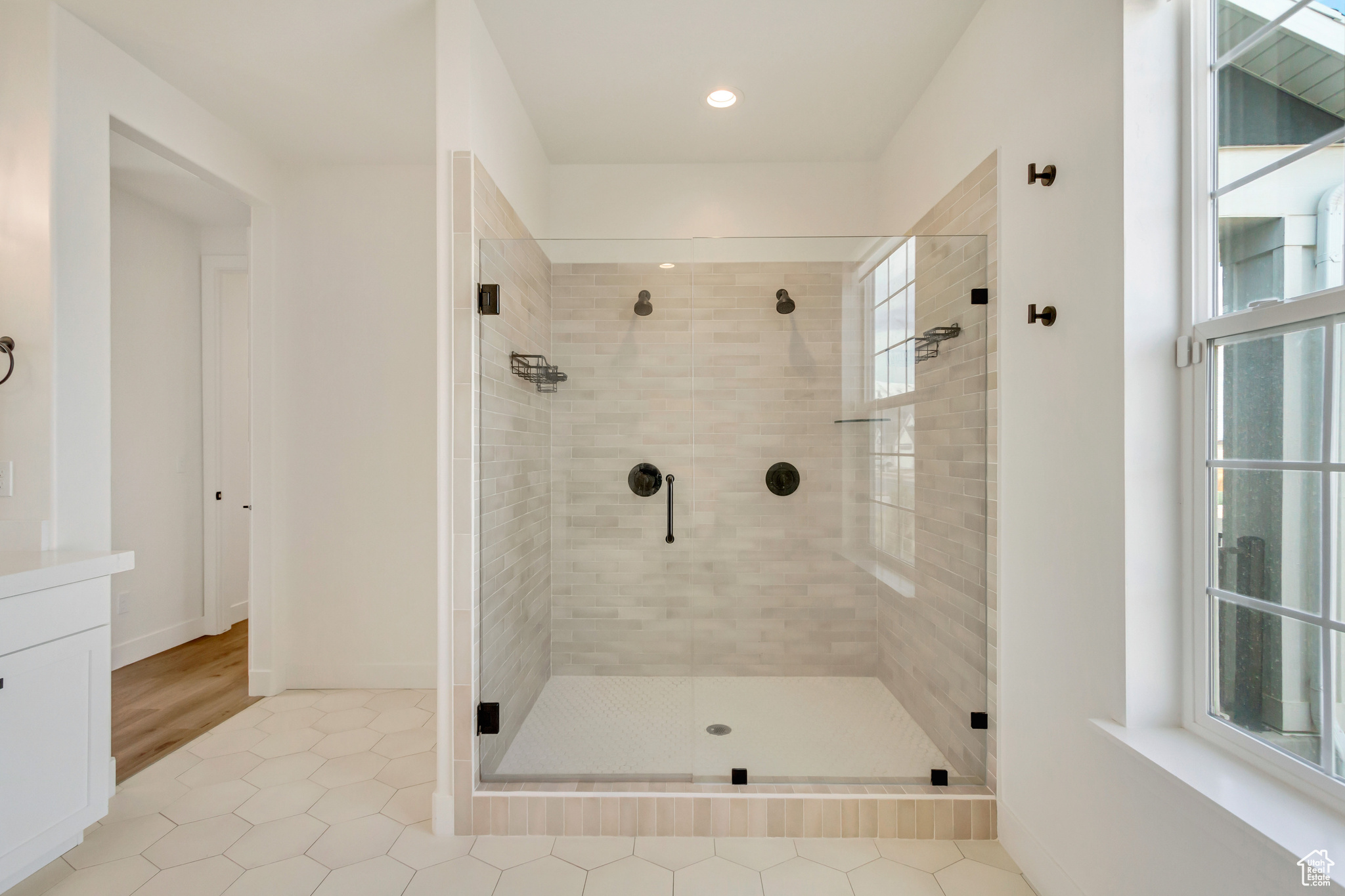 Bathroom featuring tile patterned flooring, a shower stall, and baseboards