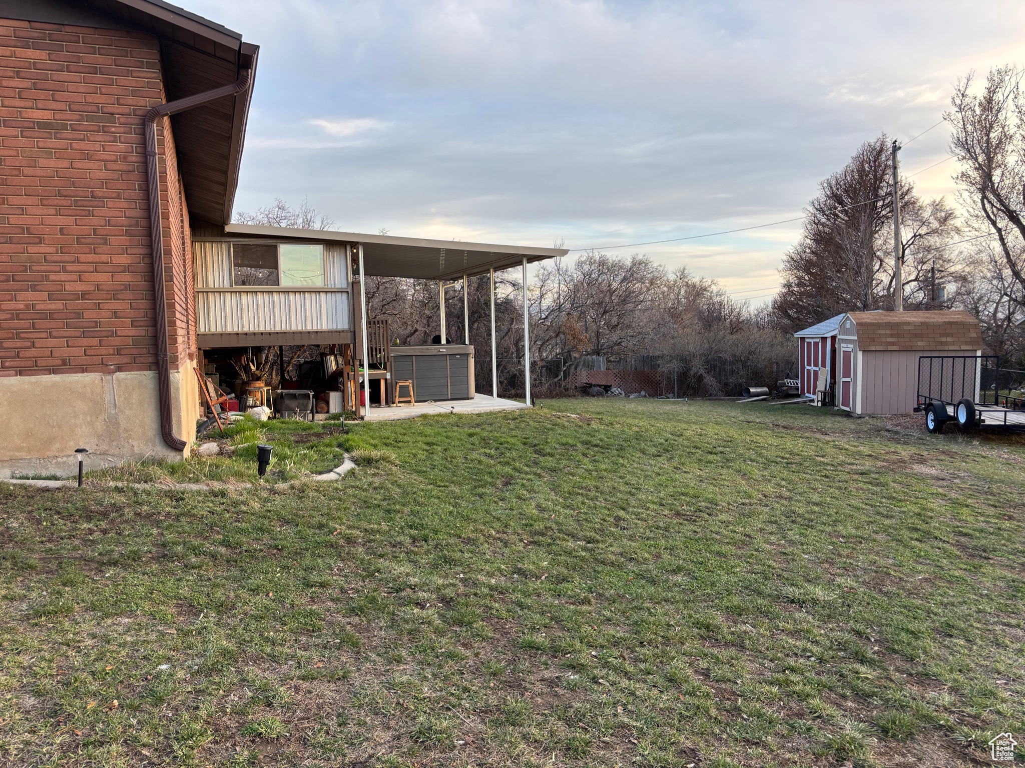 View of yard featuring a storage shed, a jacuzzi, and an outdoor structure