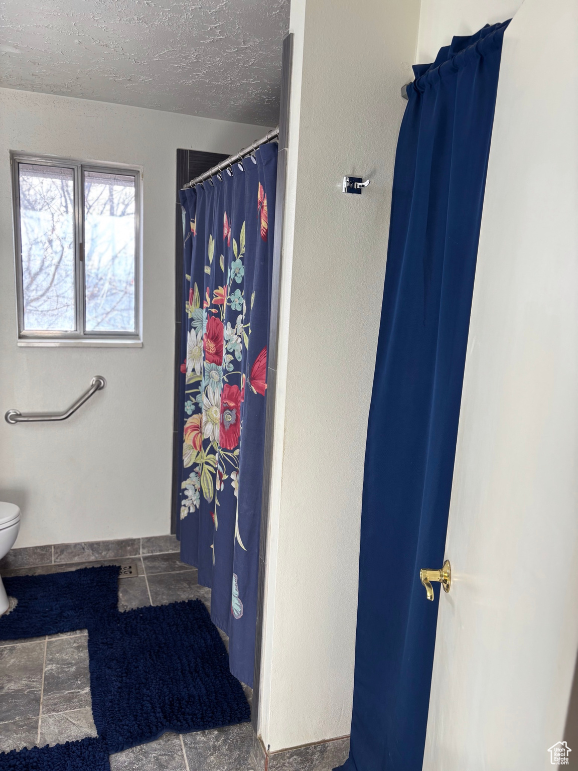 Bathroom with curtained shower, toilet, and a textured ceiling