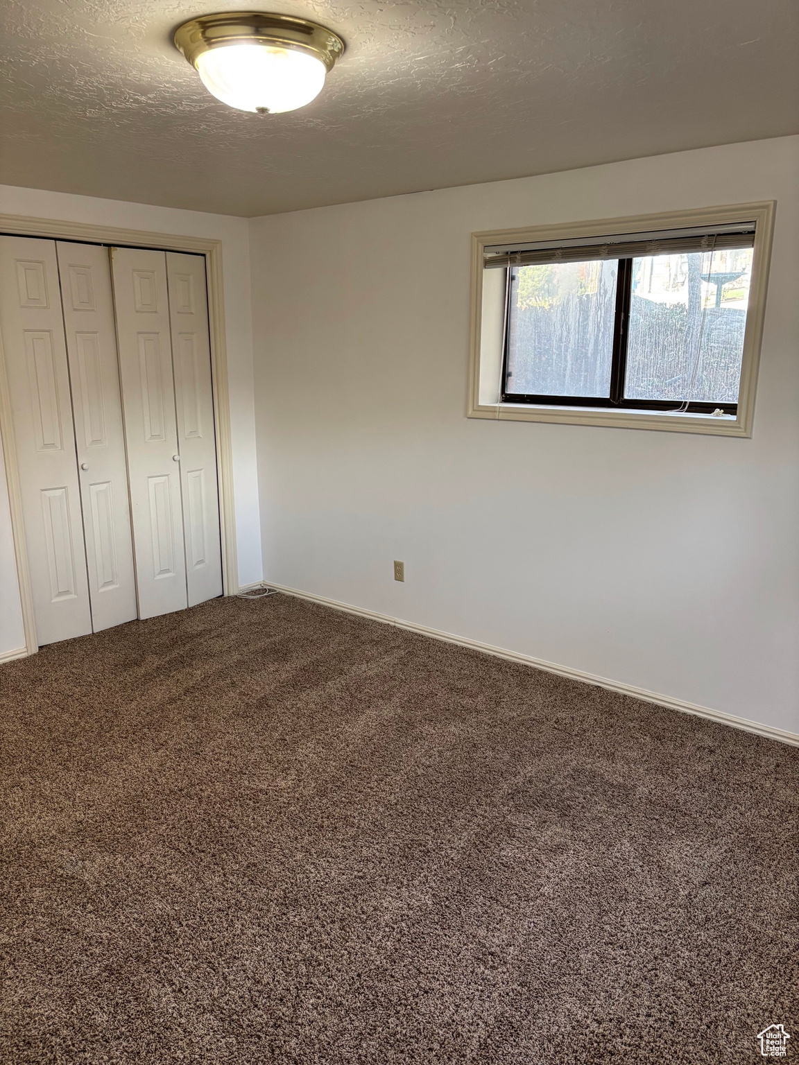 Unfurnished bedroom featuring carpet flooring, a closet, and a textured ceiling