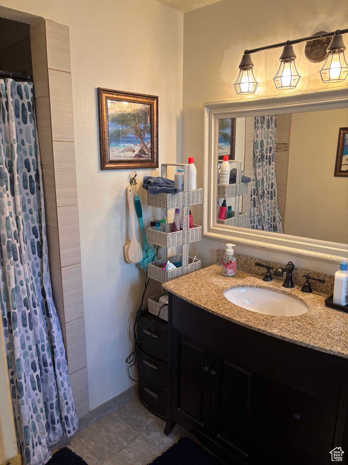 Full bath featuring vanity, a shower with curtain, and baseboards