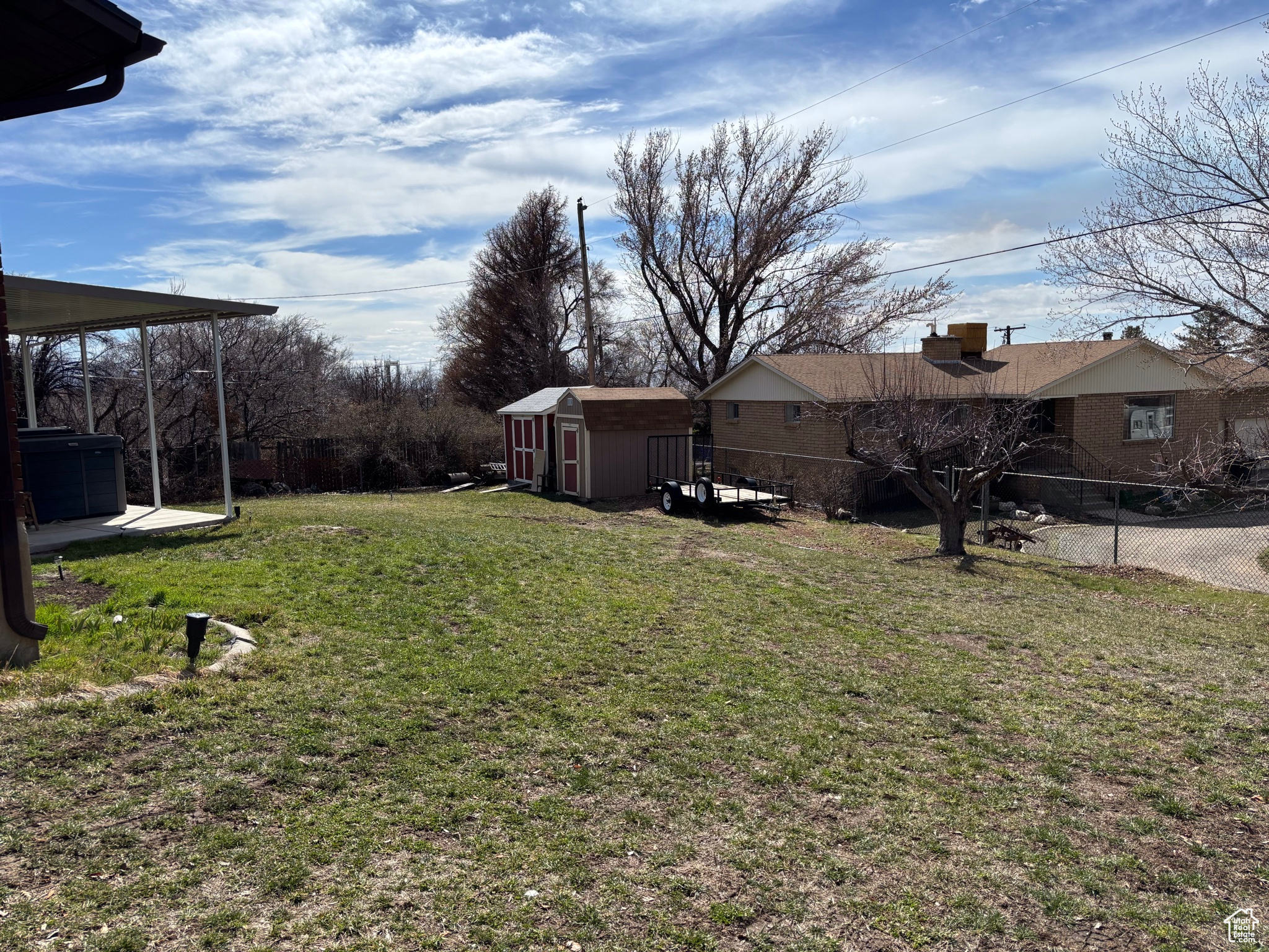 View of yard featuring an outbuilding, cooling unit, fence, and a shed