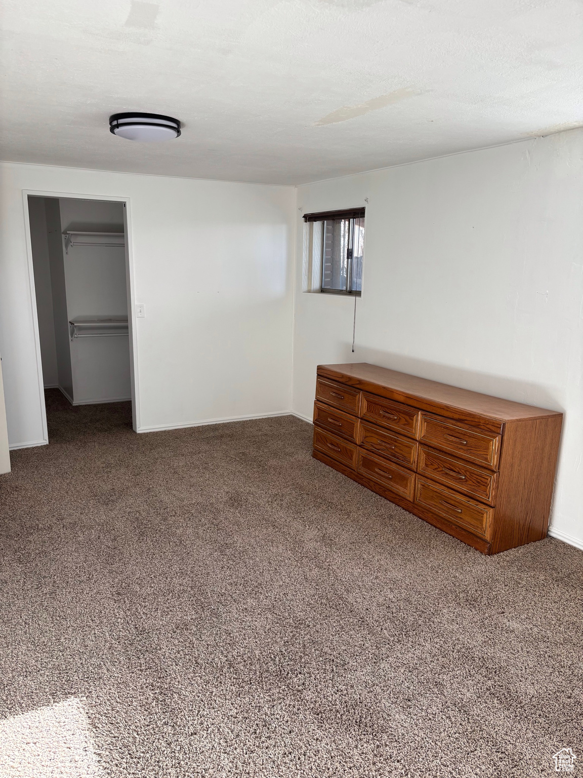 Unfurnished bedroom with carpet, baseboards, and a closet