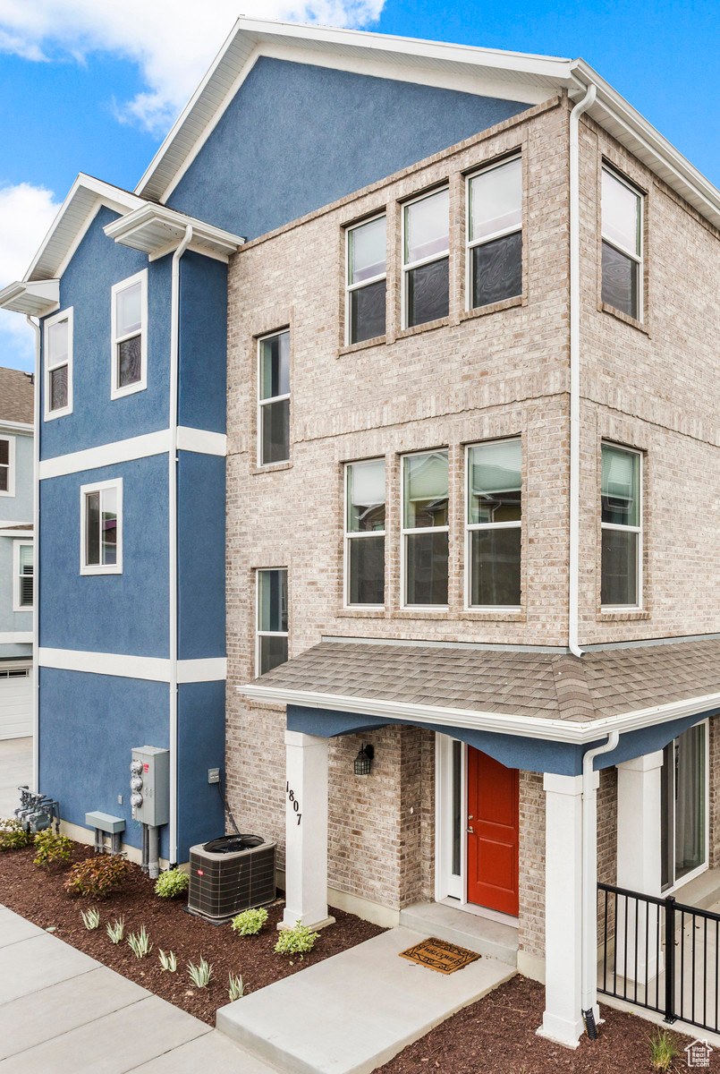 Townhome / multi-family property featuring central AC unit and stucco siding