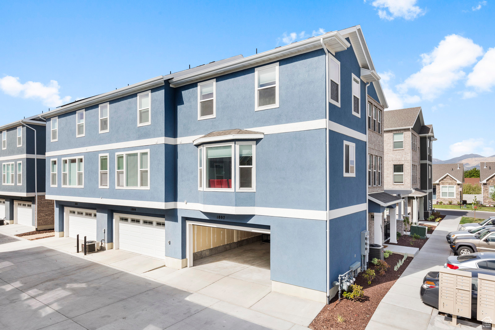 Exterior space with a garage, a residential view, and stucco siding