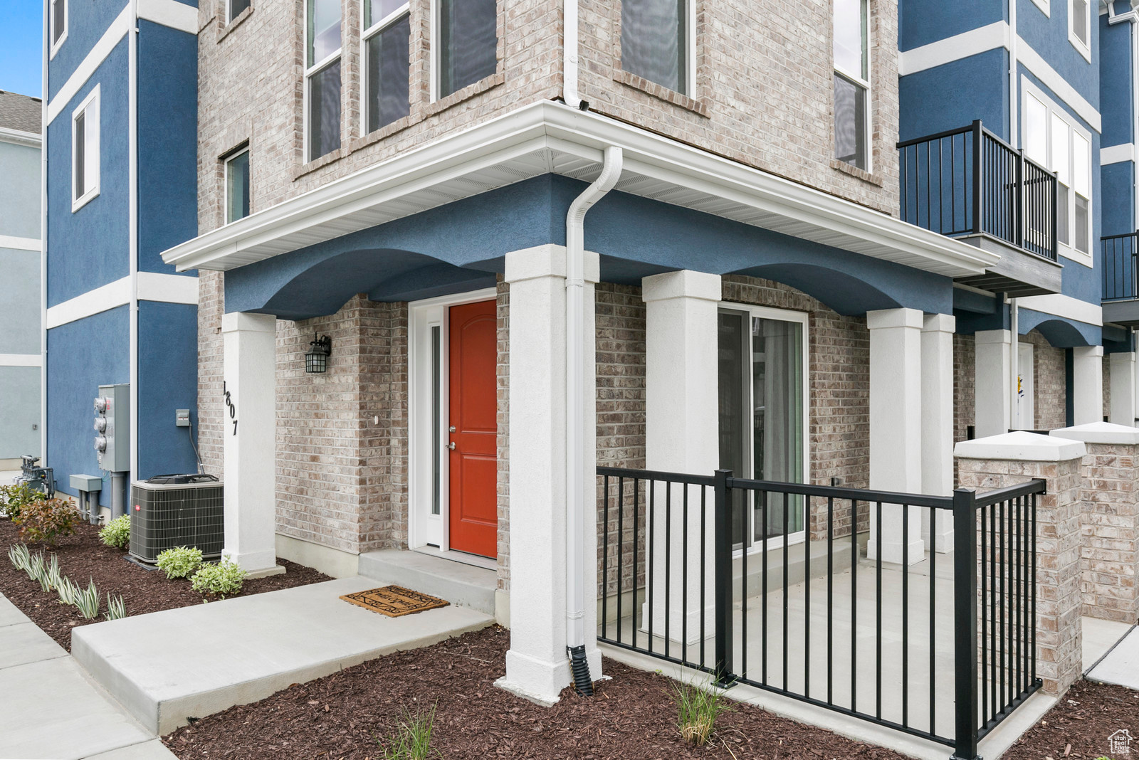 View of exterior entry featuring stucco siding and central AC unit