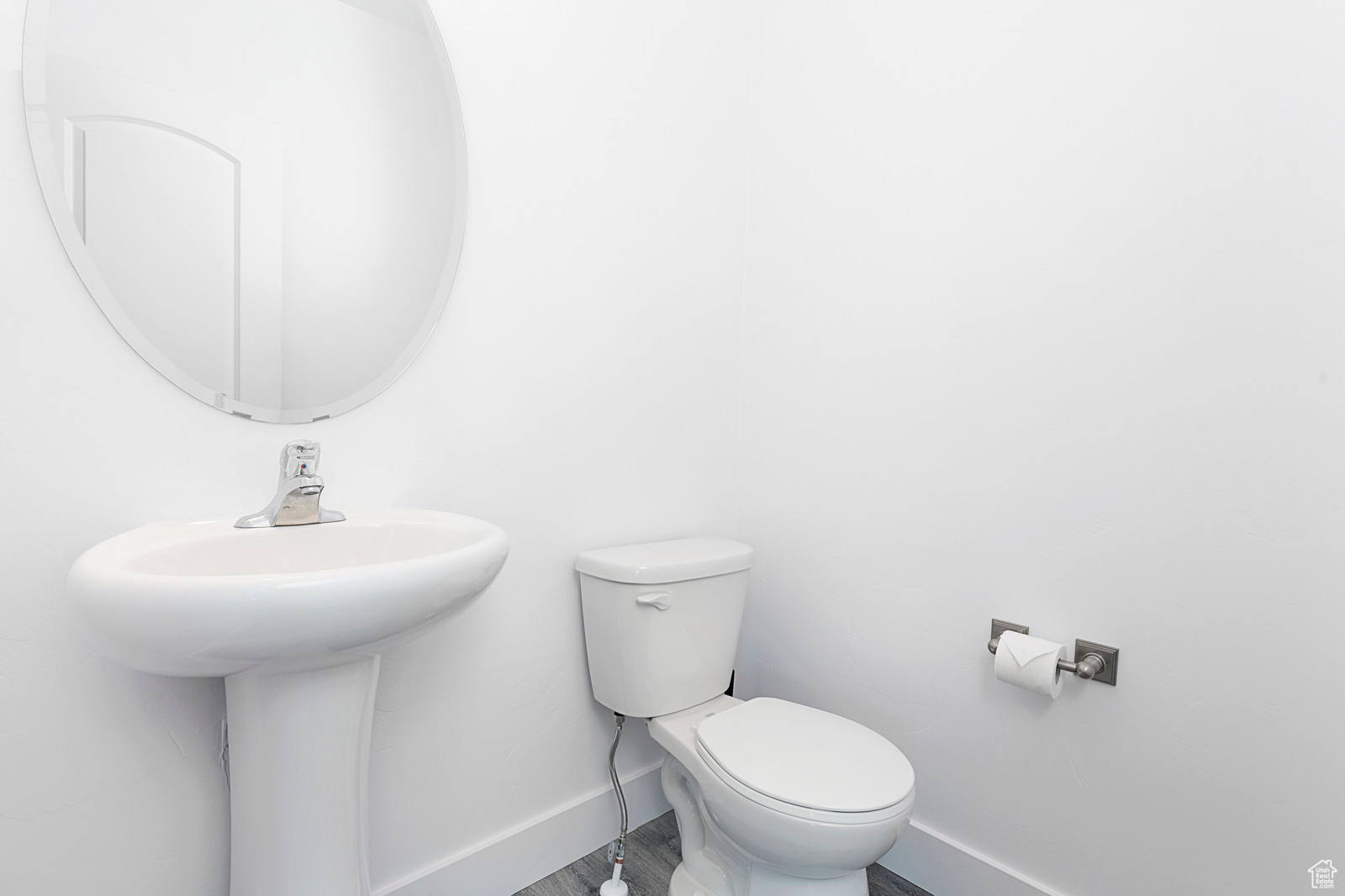 Half bath featuring toilet, baseboards, and wood finished floors