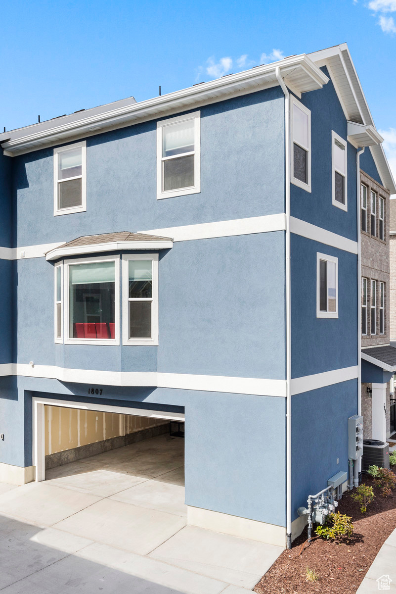 View of side of home featuring stucco siding and driveway