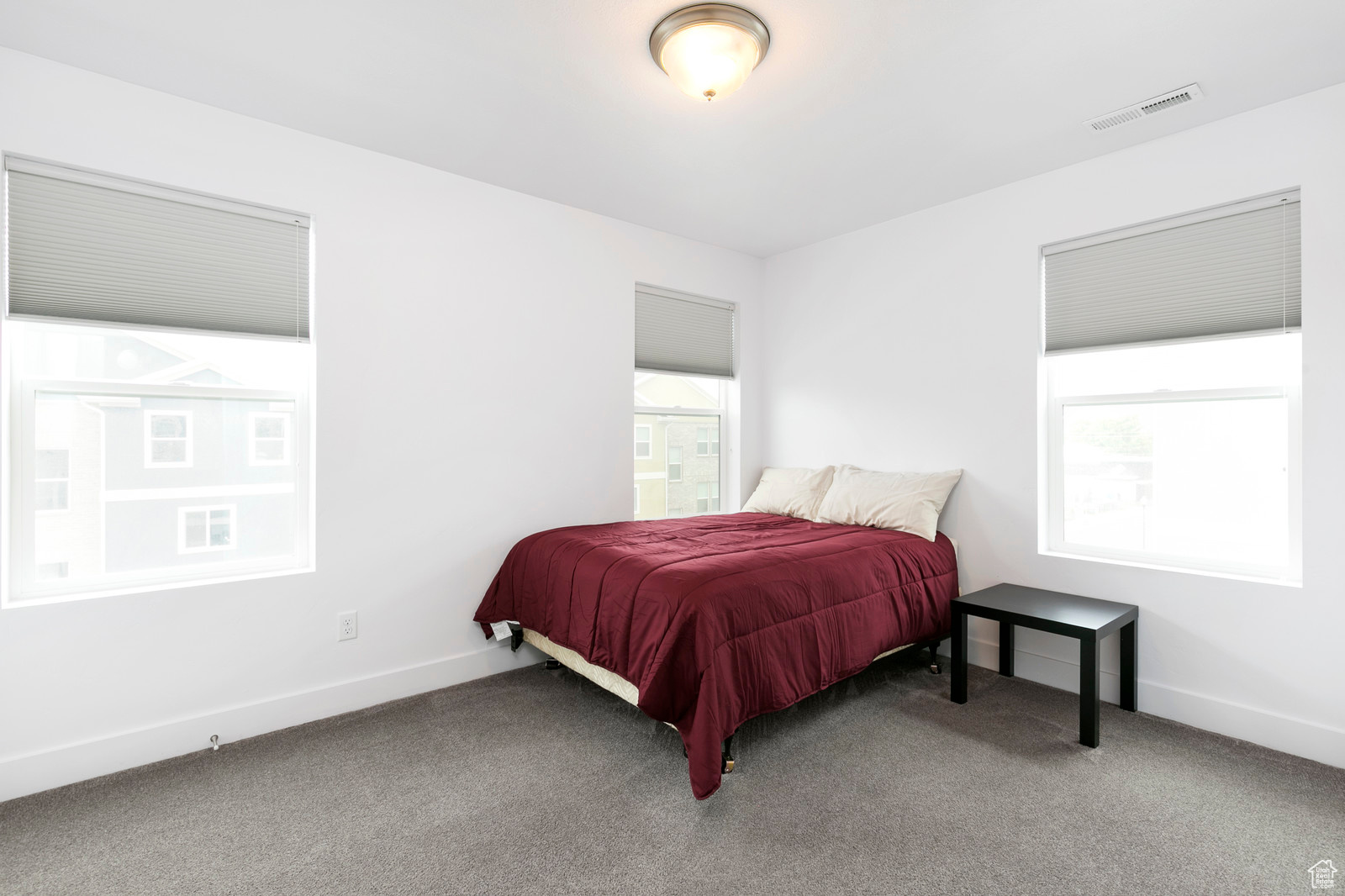 Carpeted bedroom with visible vents and baseboards