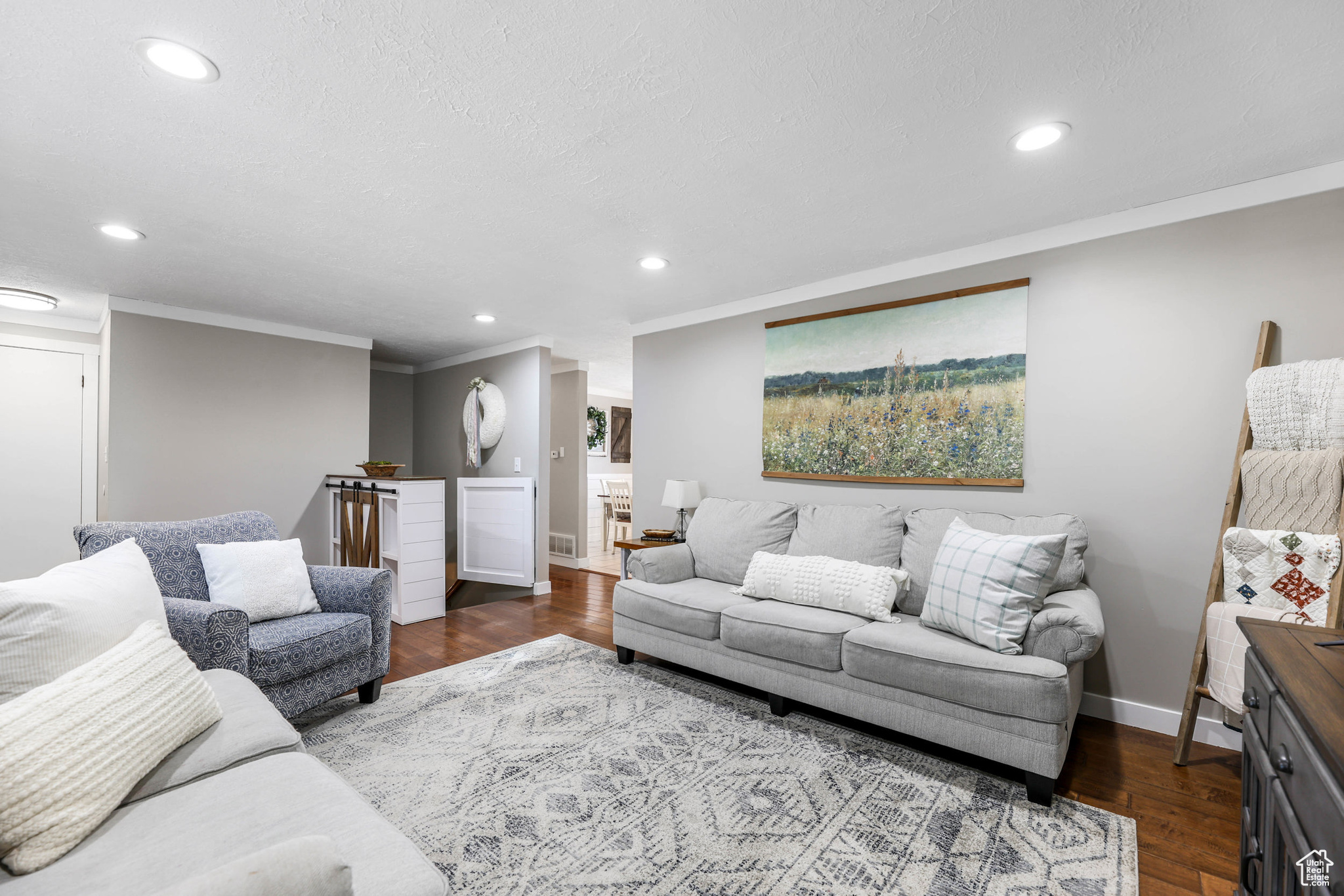 Living area with crown molding, recessed lighting, dark wood-style flooring, and baseboards