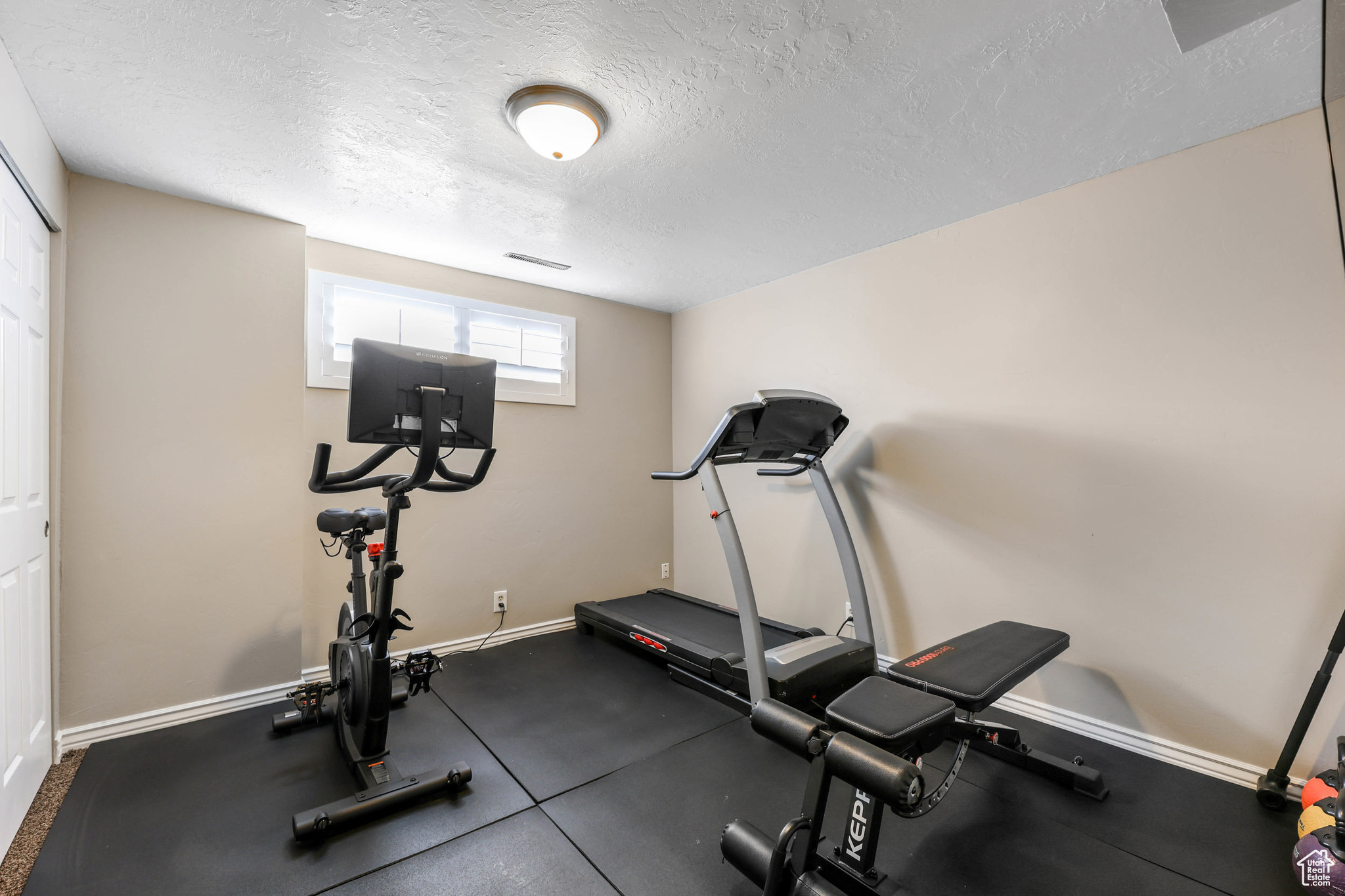 Workout area featuring baseboards and a textured ceiling