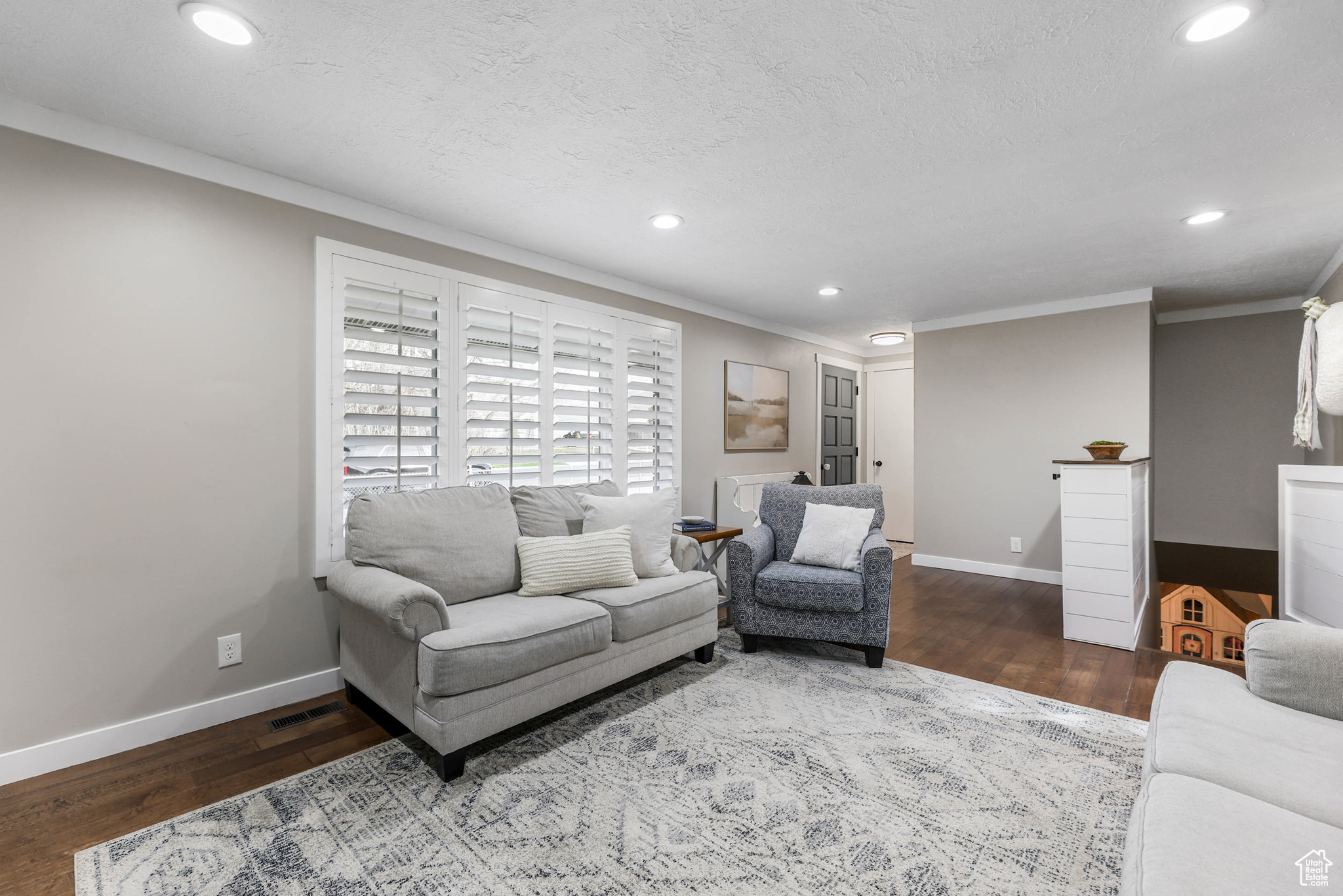 Living room featuring crown molding, baseboards, and wood finished floors