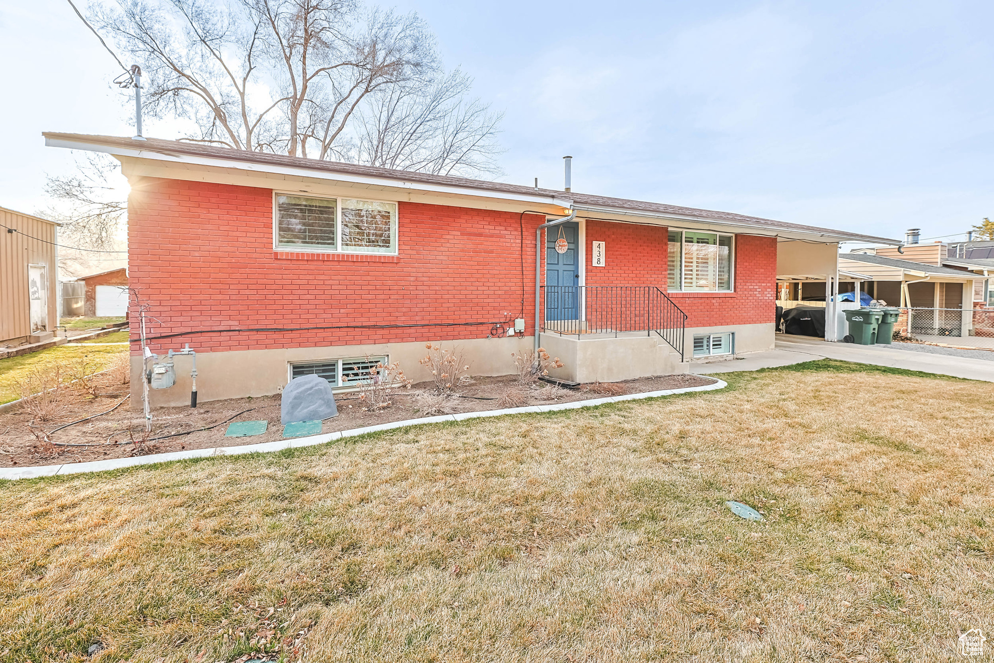 Rear view of house with brick siding and a yard