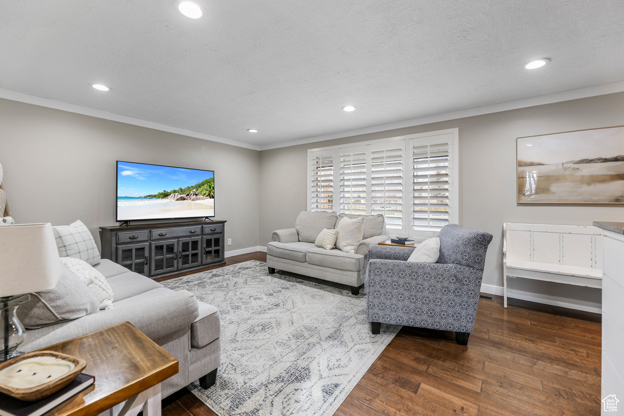 Living room with recessed lighting, baseboards, wood finished floors, and crown molding