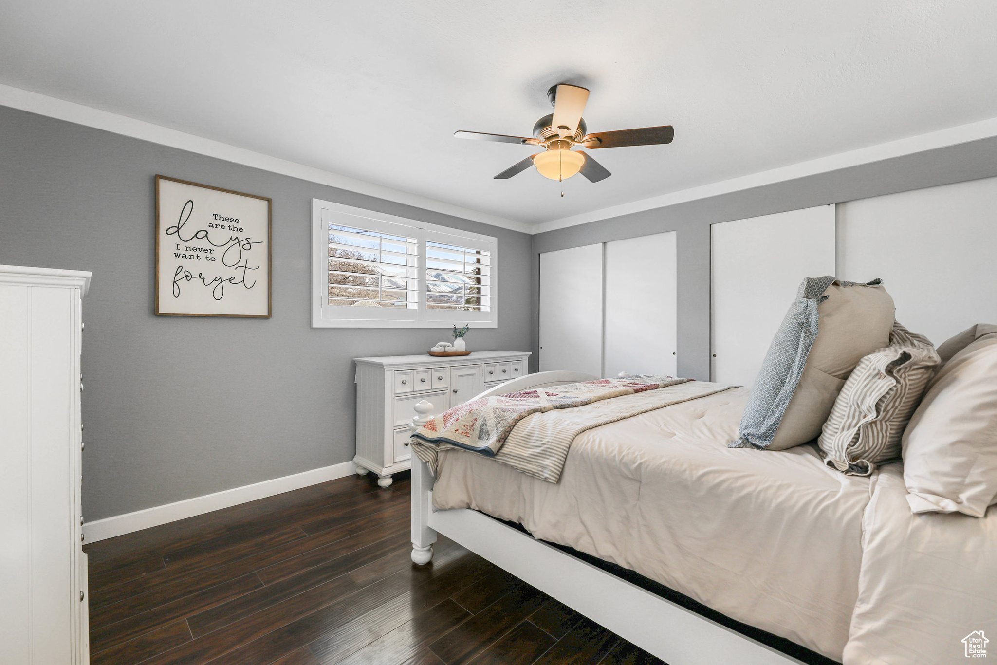 Bedroom with dark wood finished floors, ceiling fan, crown molding, and baseboards